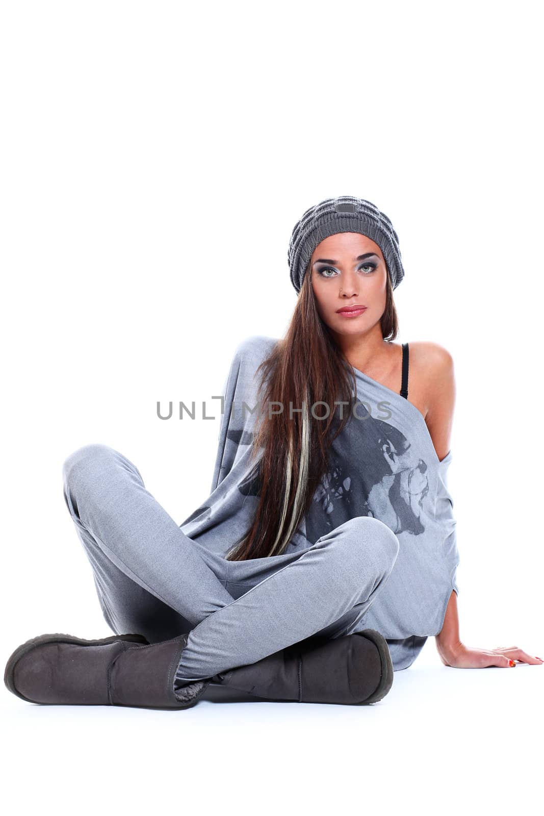 Cute and modern woman in hat sitting over a white background