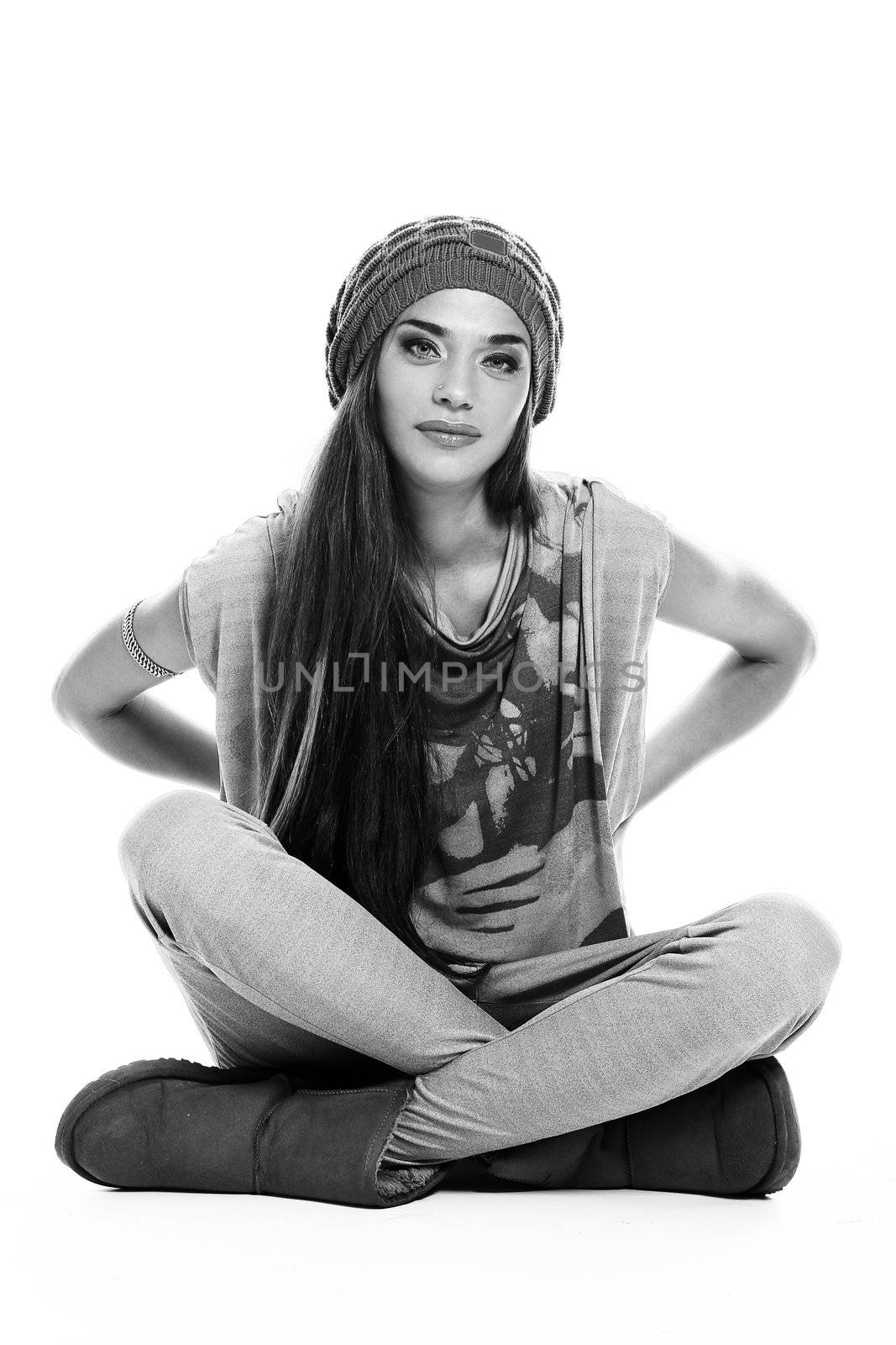 black and white portrait of cute and modern woman in hat sitting