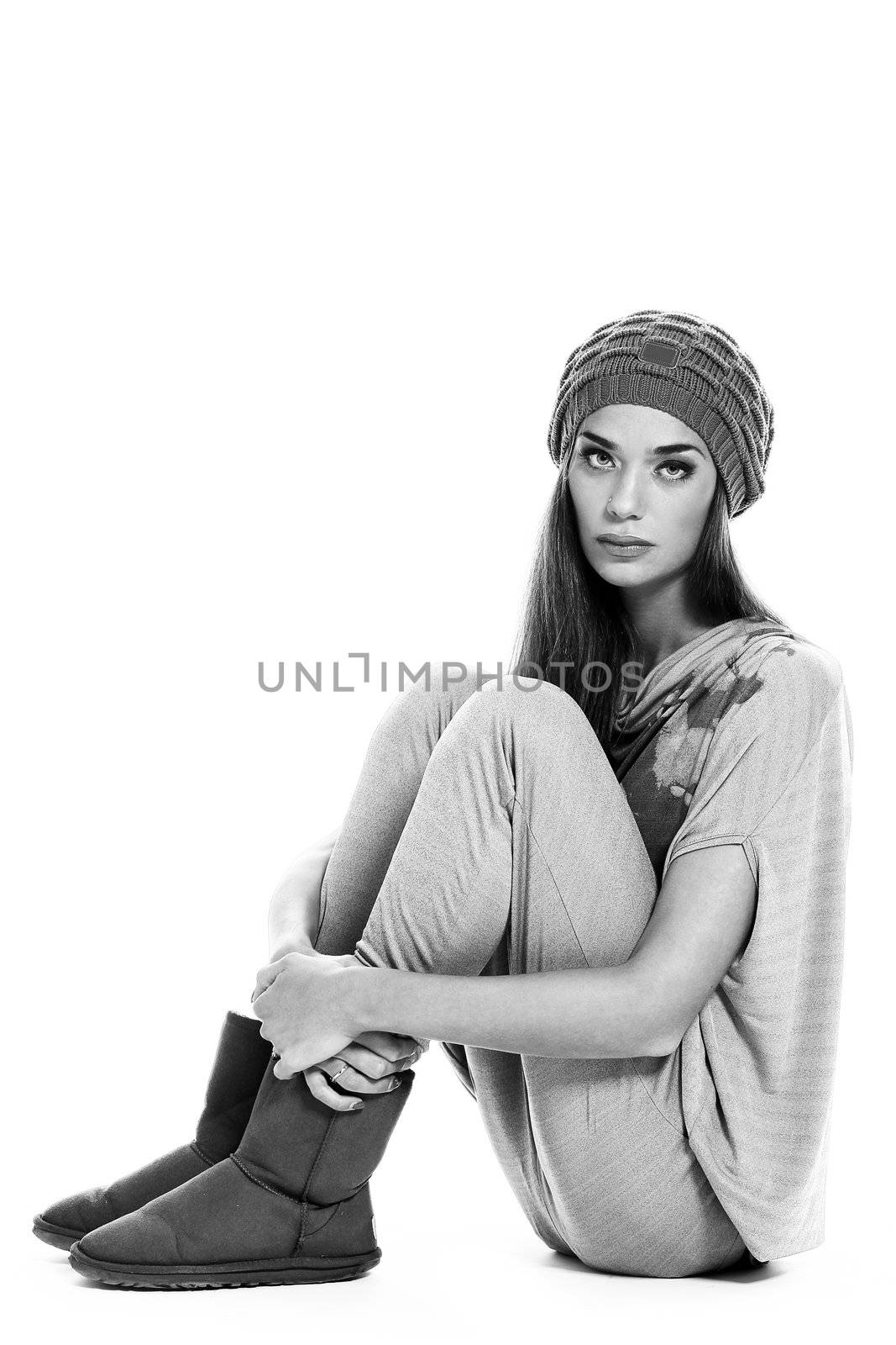 black and white portrait of cute and modern woman in hat sitting