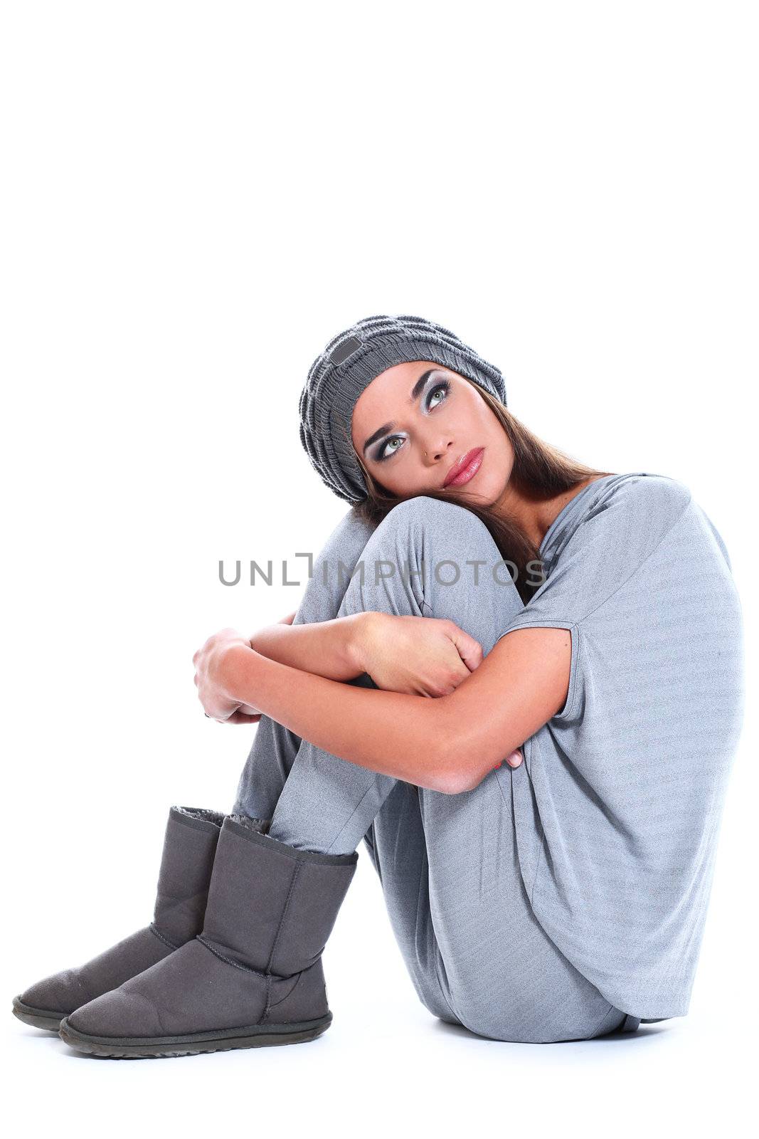 Cute and modern woman in hat sitting over a white background