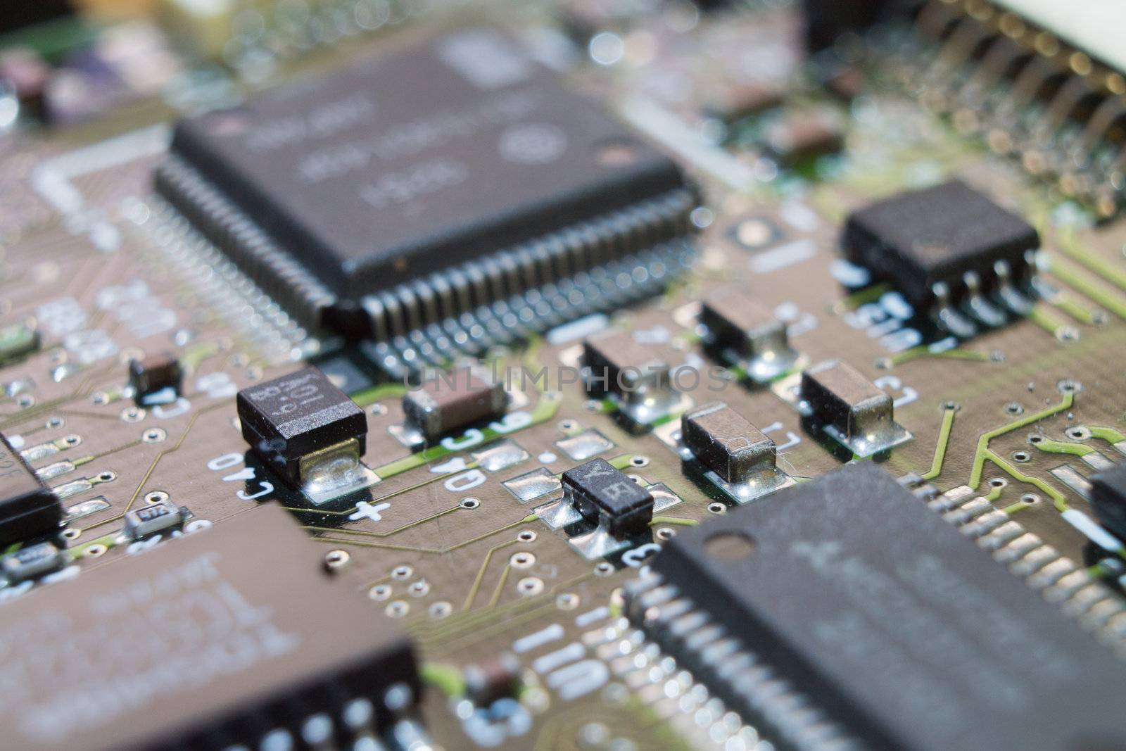 Microchips surrounded by other elements on a circuit board