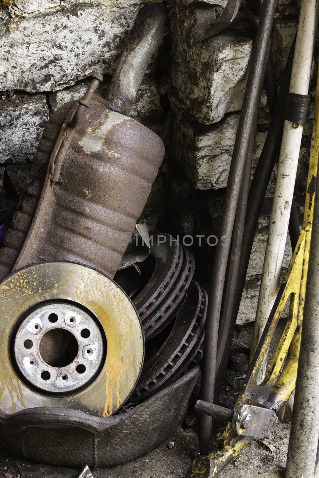 Discarded motor vehicle exhaust and clutch plate in corner of a garage