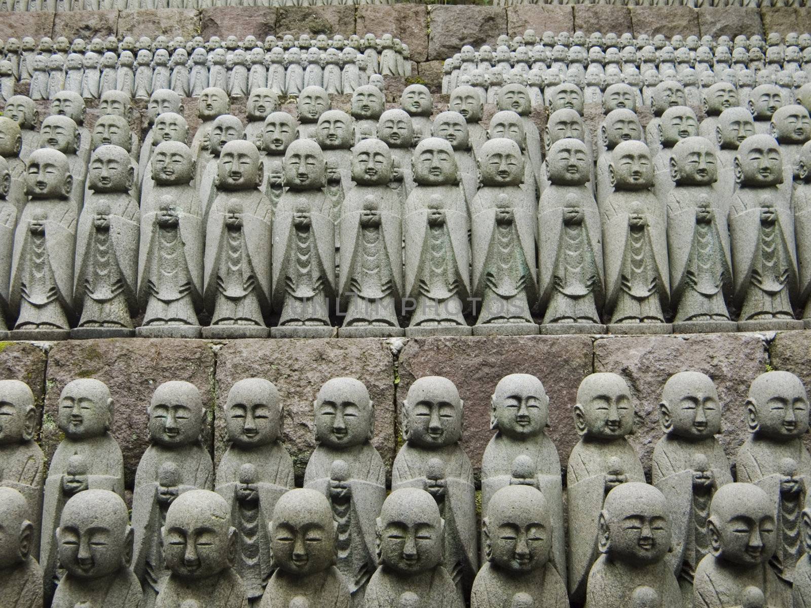 rows of similar japanese jizo sculptures in Hase-Dera temple, Kamakura, these jizo stay here for comfort of  unborn children