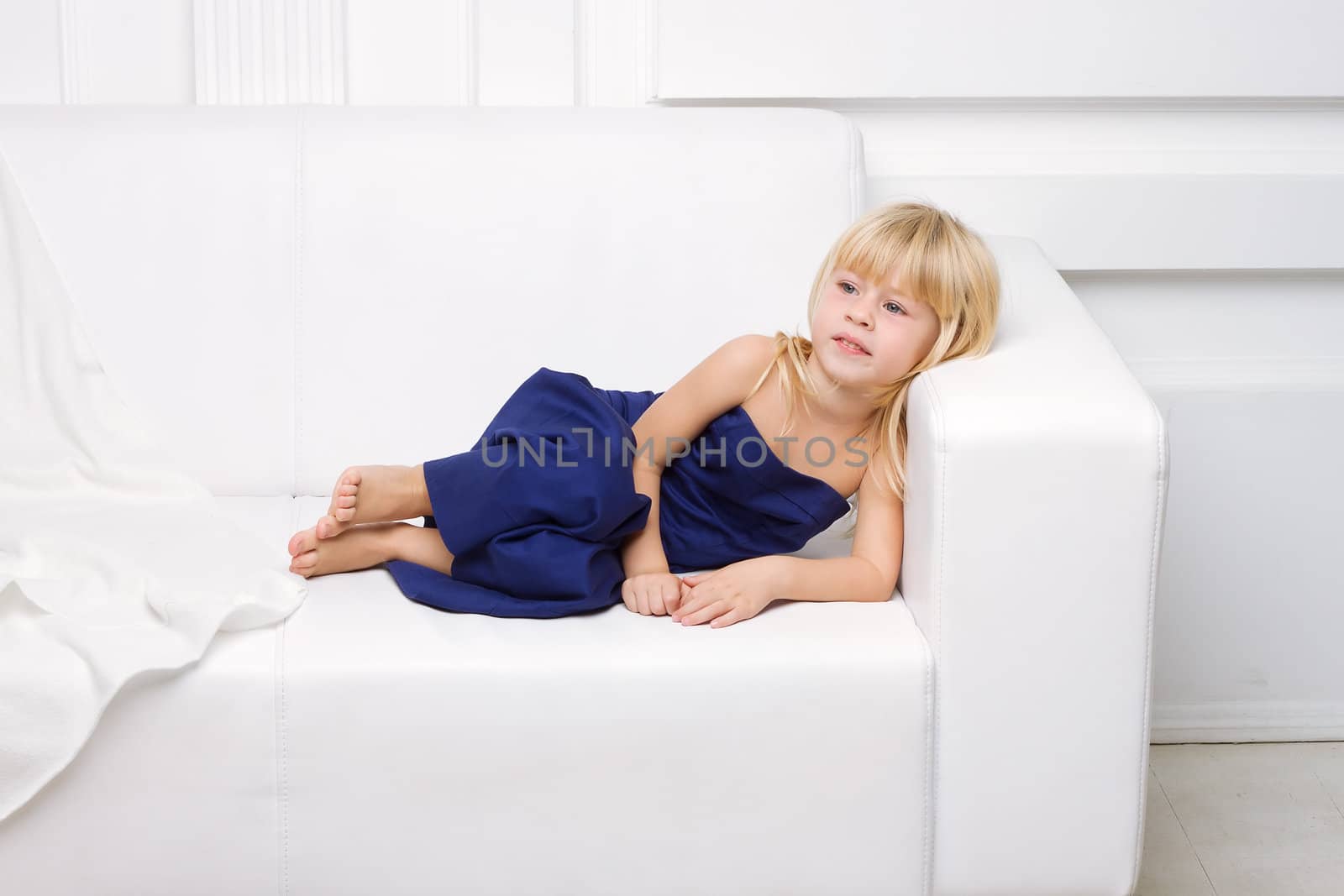 girl is in blue dress on a white sofa by victosha