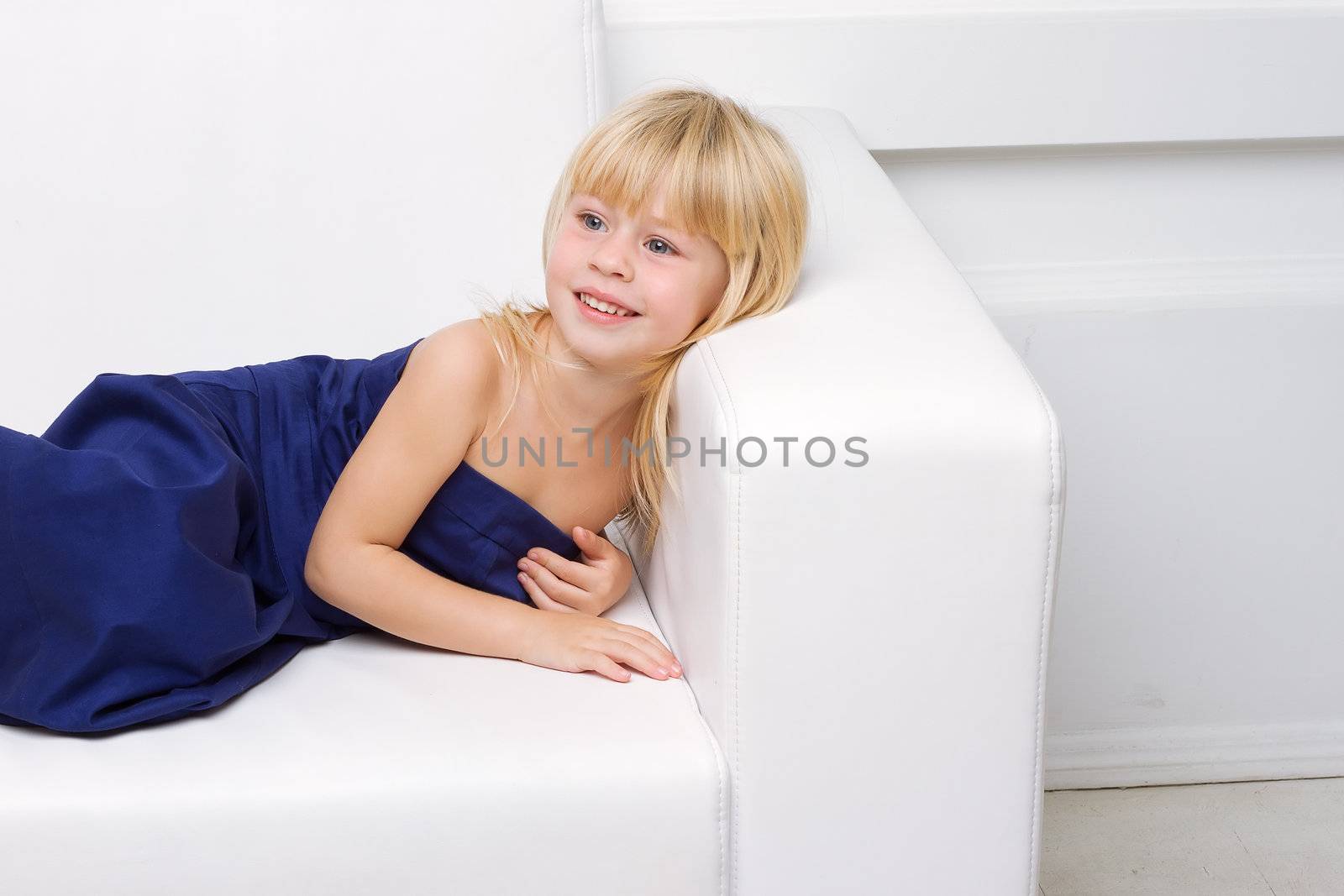 girl is in blue dress on a white sofa by victosha