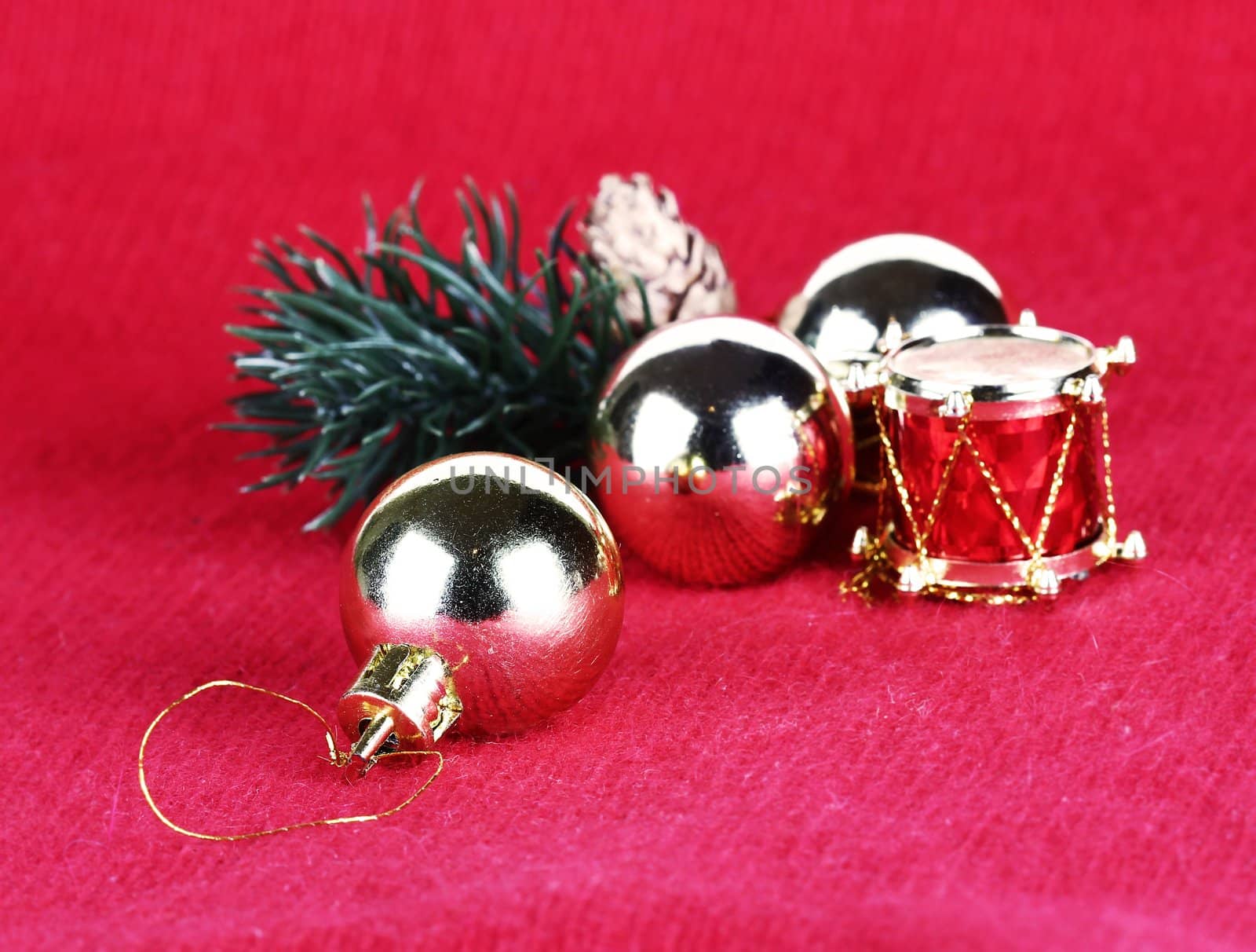 Golden Christmas  balls and toy drum on red background