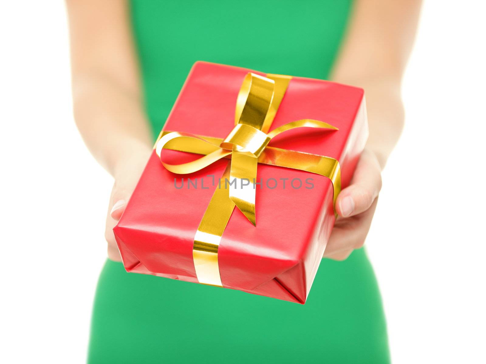 Gift. Woman giving red christmas gift / present. Closeup of woman holding and showing red Christmas present with gold ribbon on pure white background.