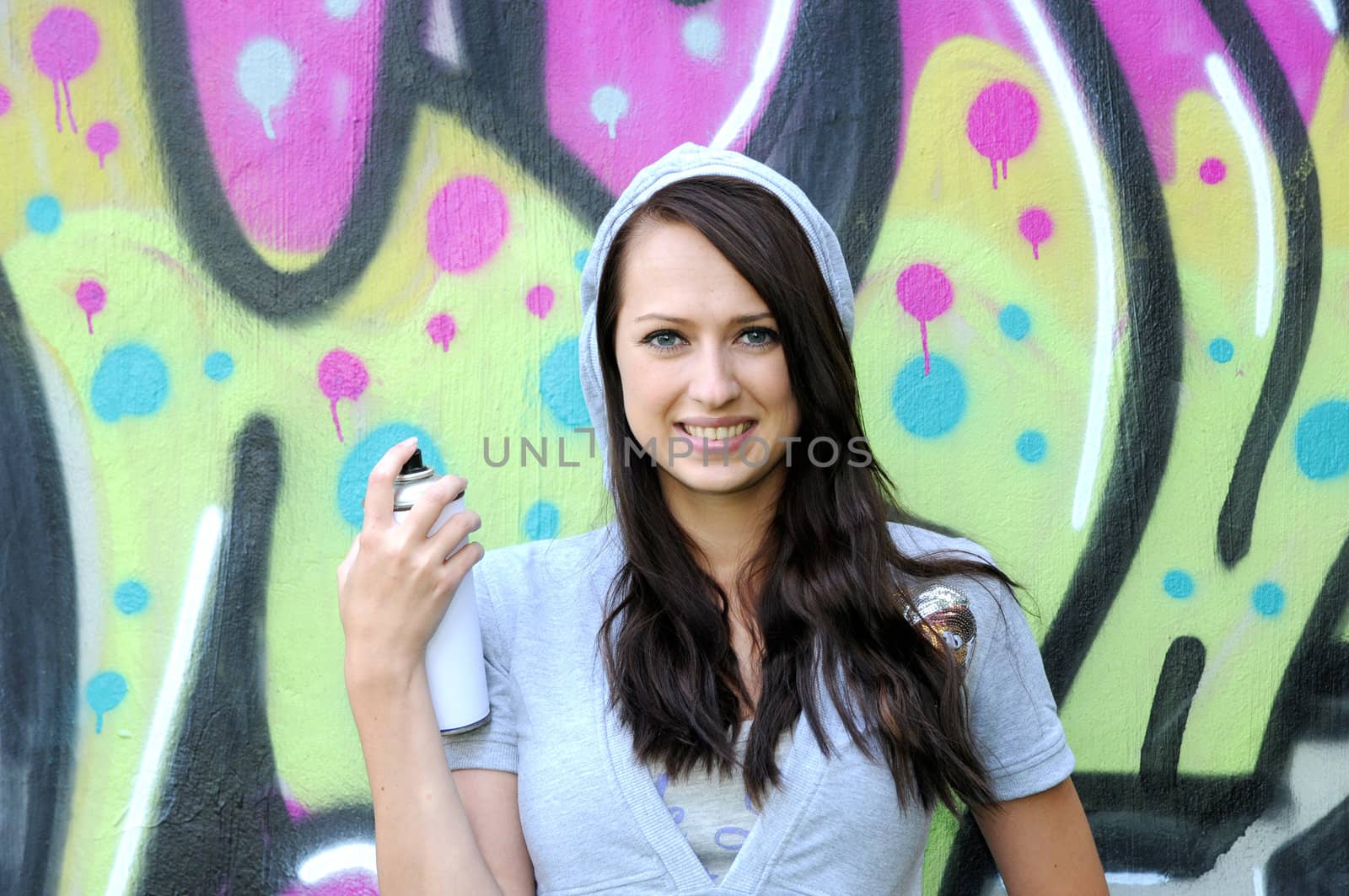 Young and beautiful girl posing against wall with graffiti