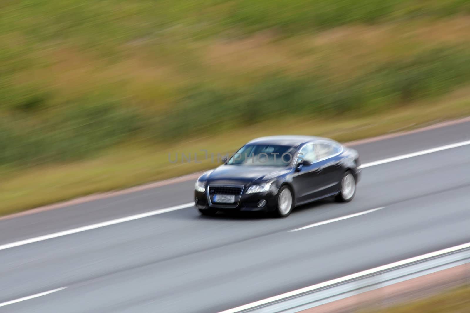 Beautiful black car in full speed on the motorway, blurred image.