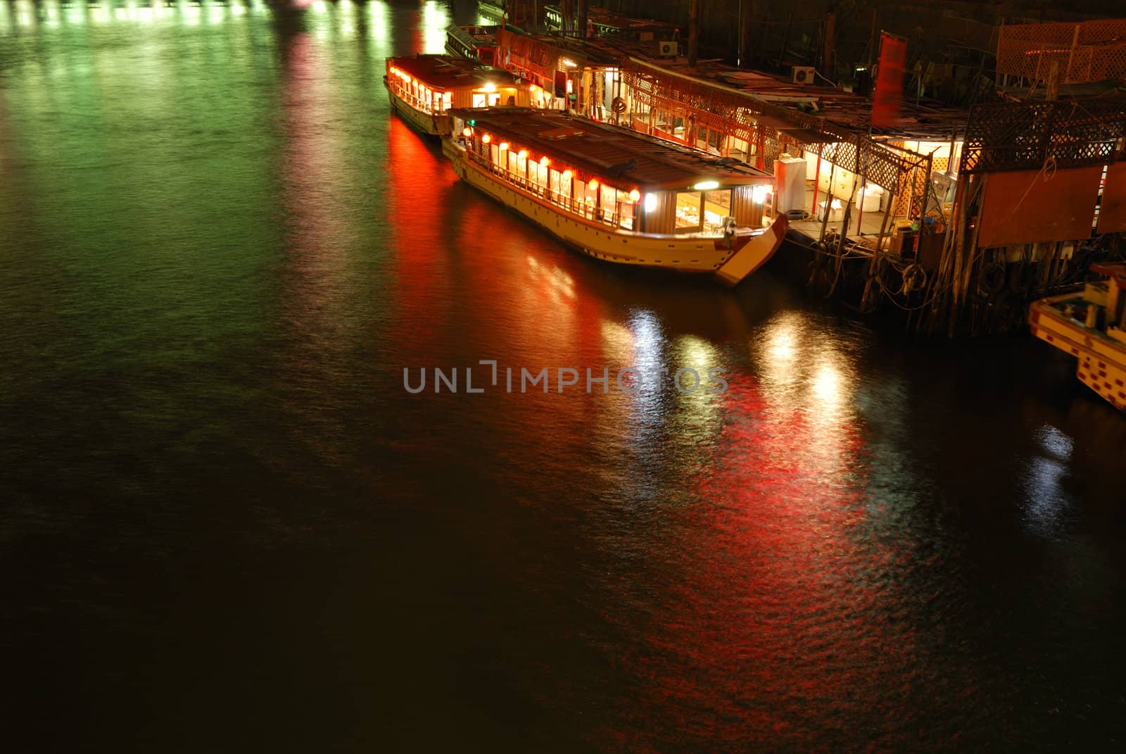 Japanese boat near pier in the night; boat is little blurred due to long exposure; pier is sharp,  Tokyo, Japan