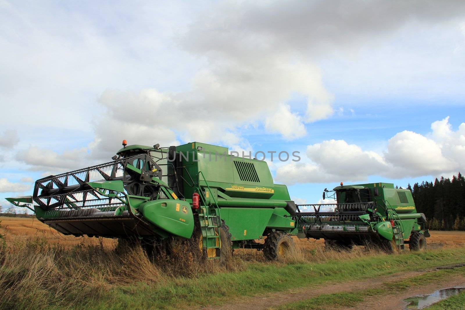SALO, FINLAND - CIRCA OCTOBER 2012 - Two John Deere Harvesters standing by stubble field. Due to wet and cool weather conditions in 2012, the harvesting season is several weeks late.