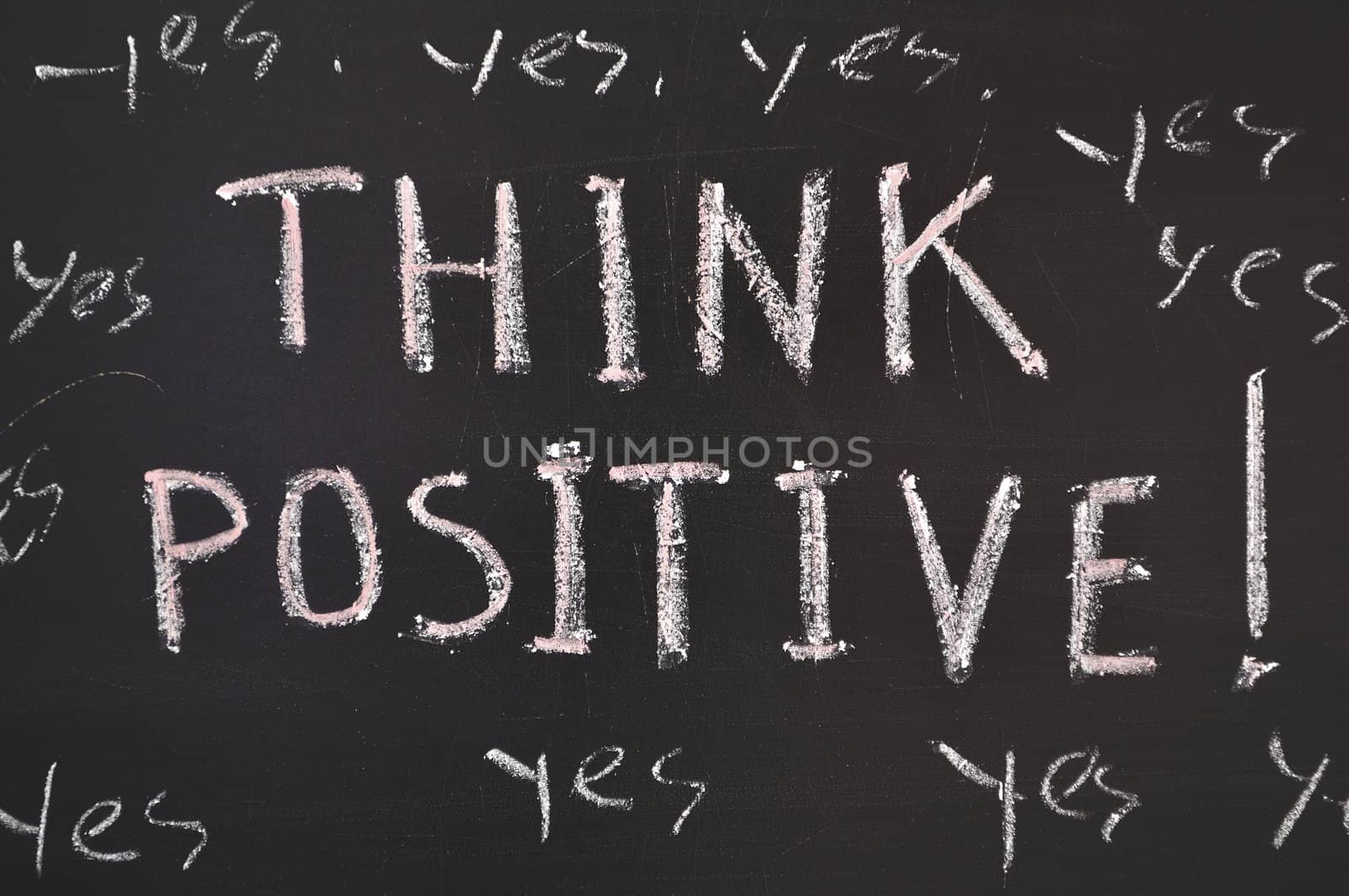 think positive concept handwritten on black chalkboard
