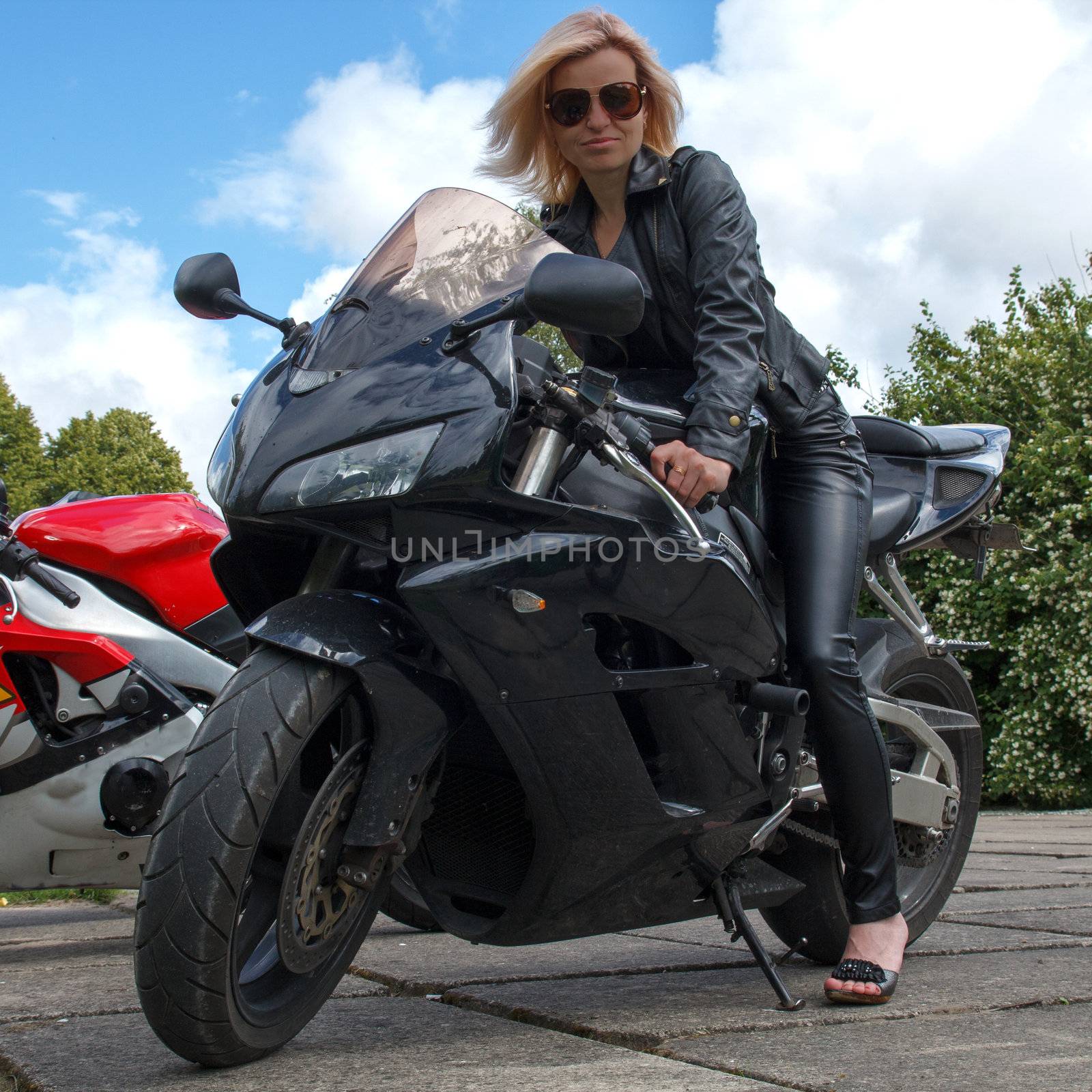 biker girl dressed in leather clothes a black motorcycle