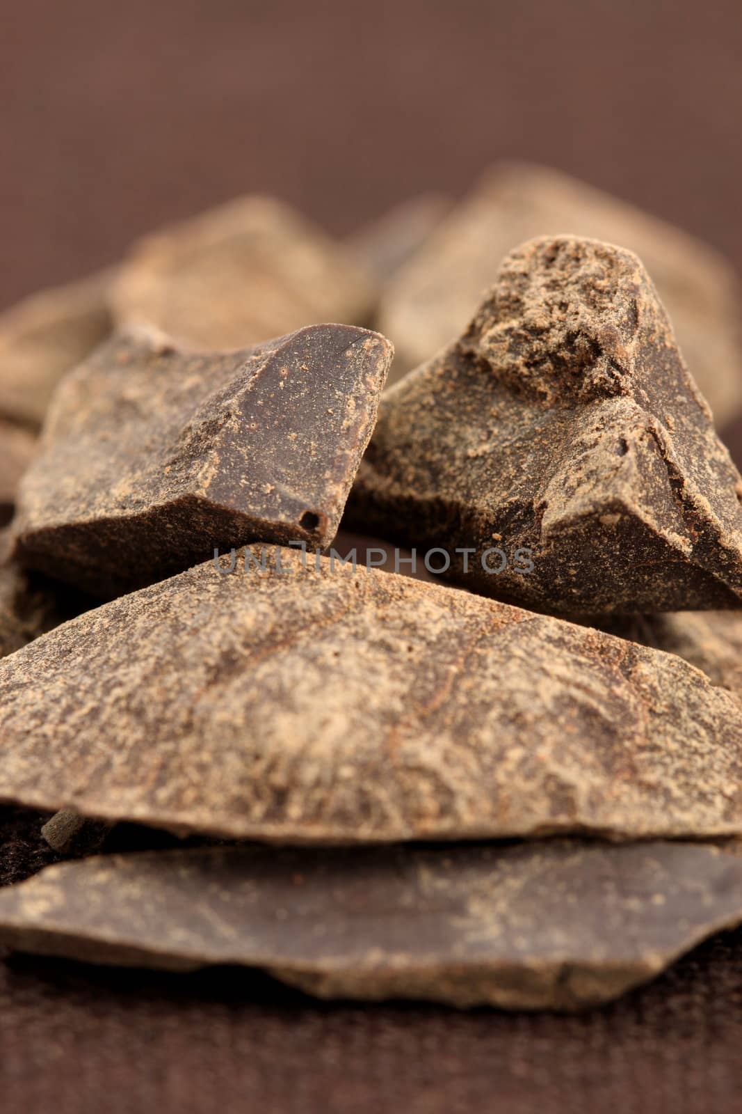 pieces of  dark organic chocolate on fancy linen ,delicious dessert or food ingredient 