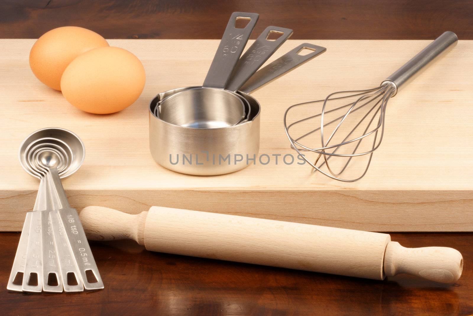 set of measuring spoons and other kitchen utensils on wood cutting board