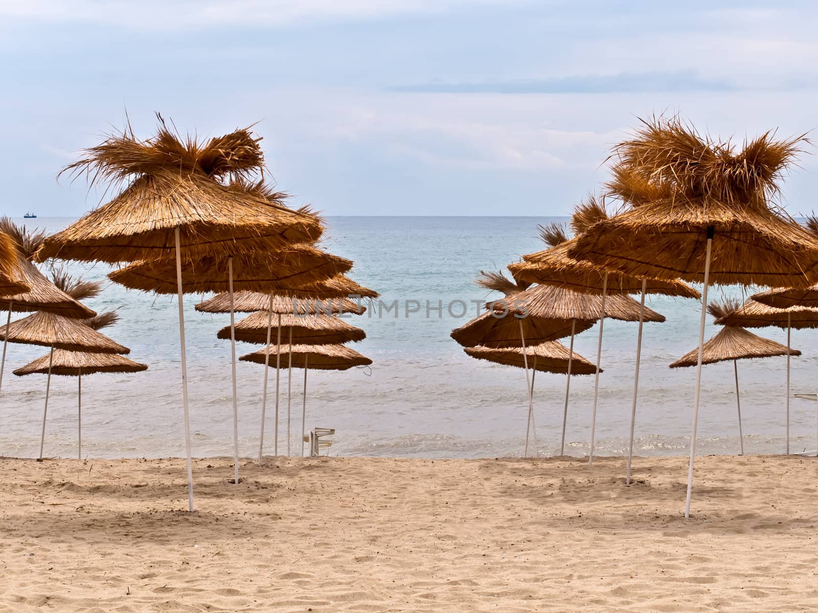 View of the beach with  straw umbrellas.