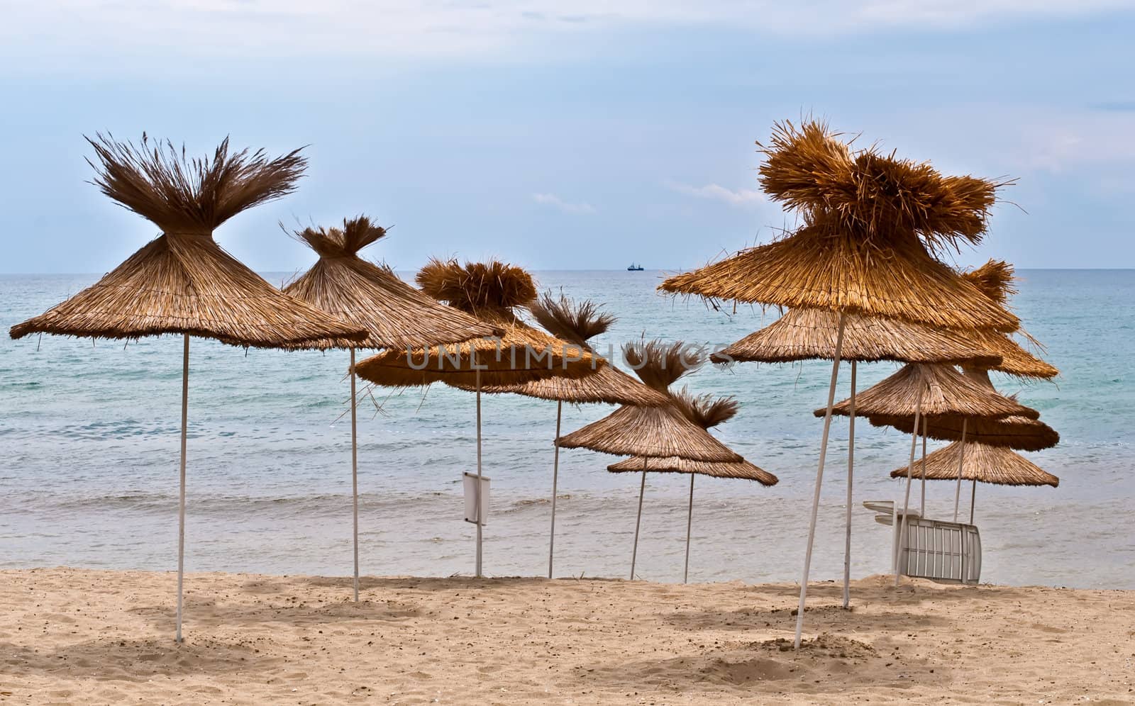 View of the beach with  straw umbrellas.