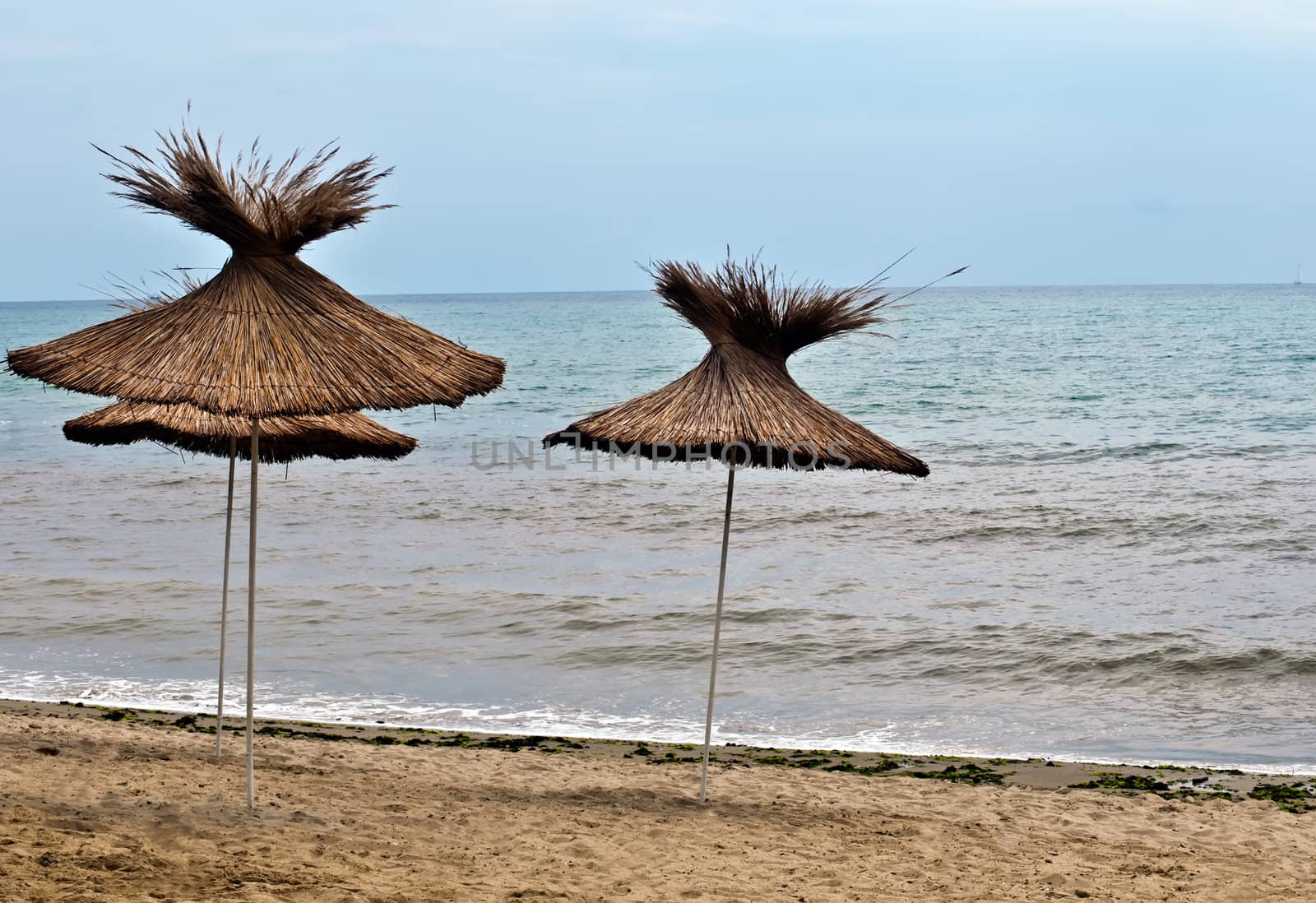 View of the beach with  straw umbrellas.