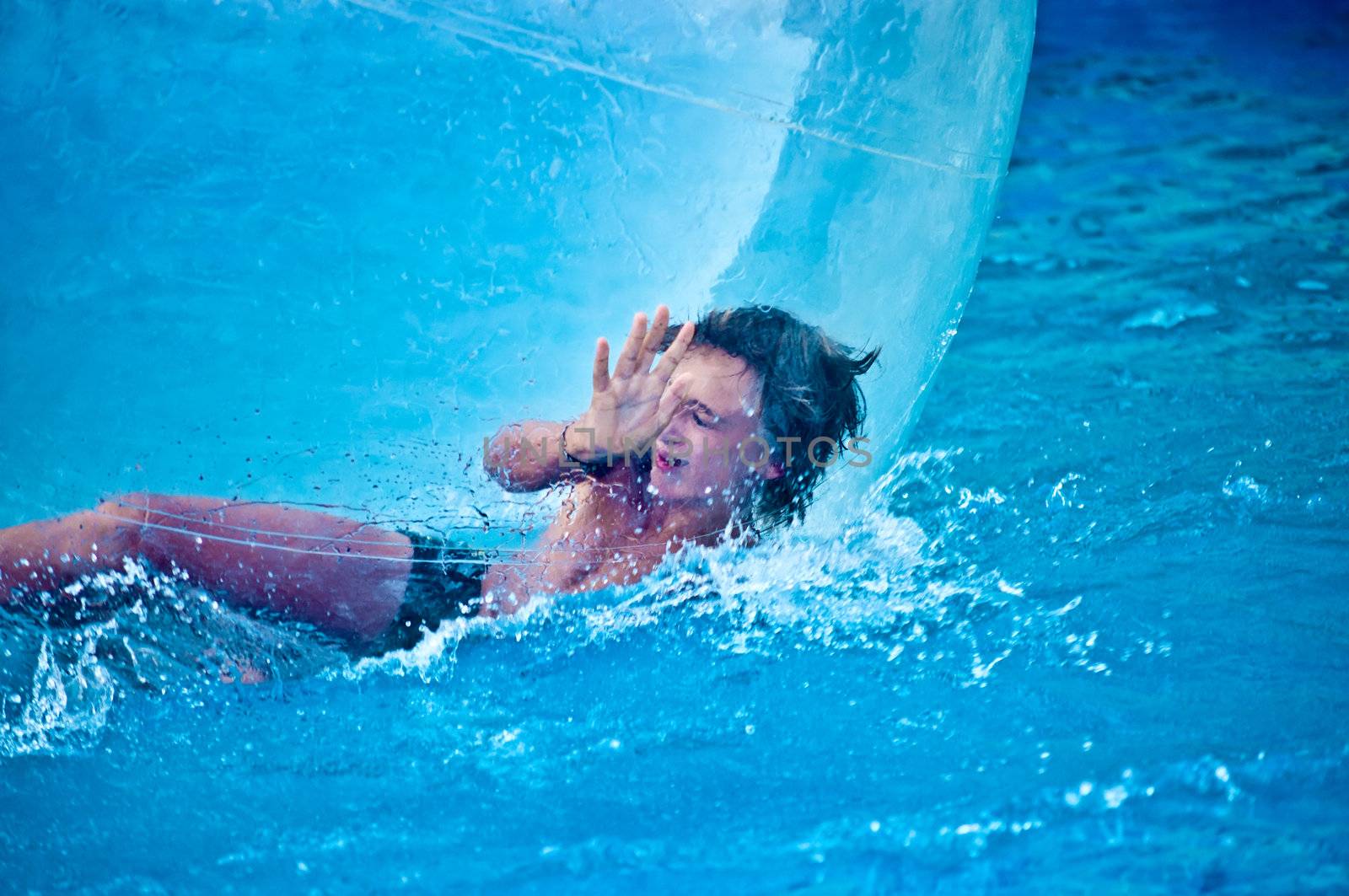 Boy in the air ball in the water in the pool.