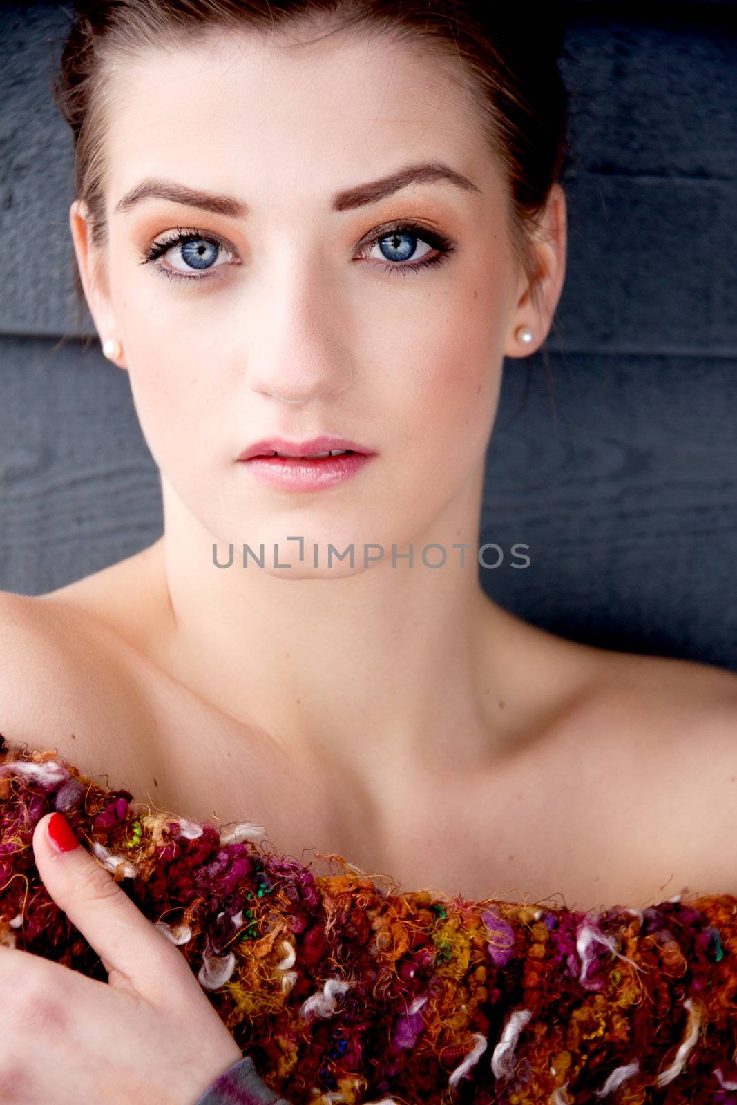 portrait brunette woman with blue eyes on blue background