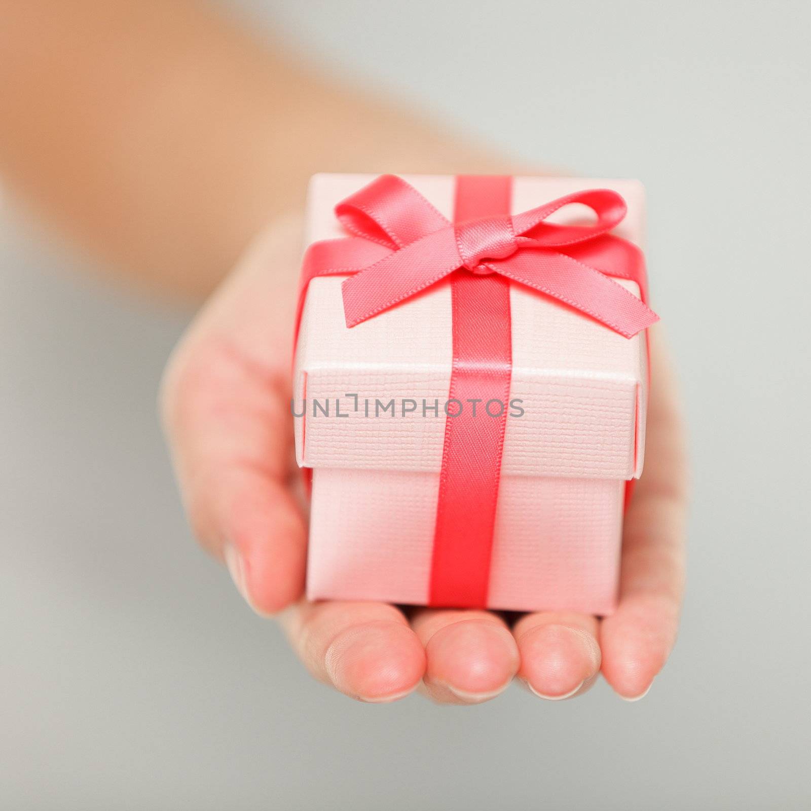 Gift closeup. Red present of gift in closeup in woman hand.