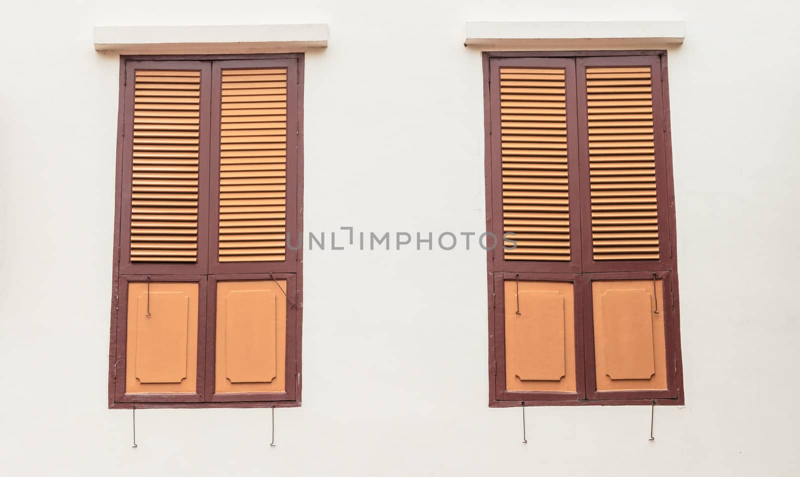 Two wooden windows on plain wall by punpleng