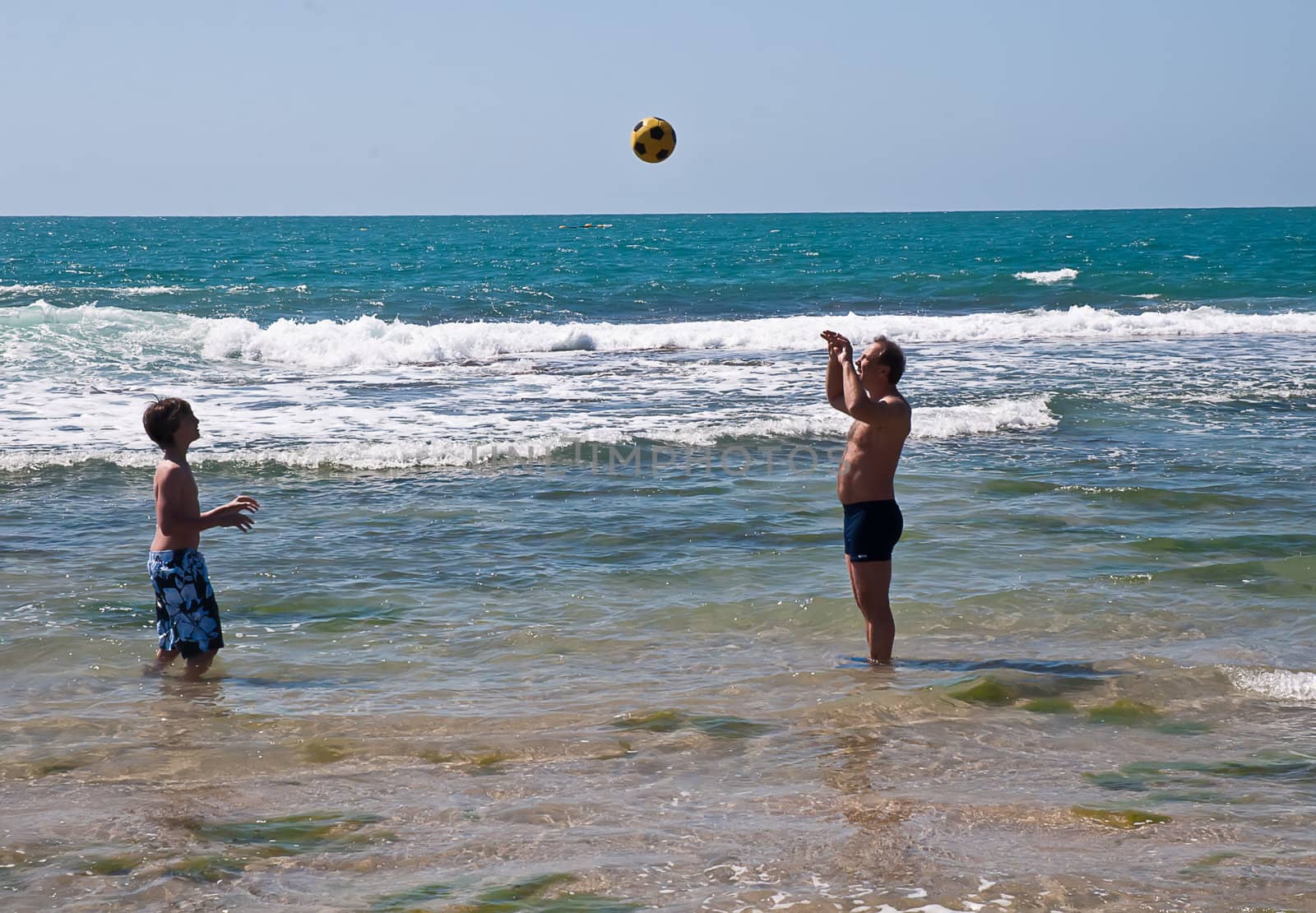 Happy father and his son playing with a ball . by LarisaP