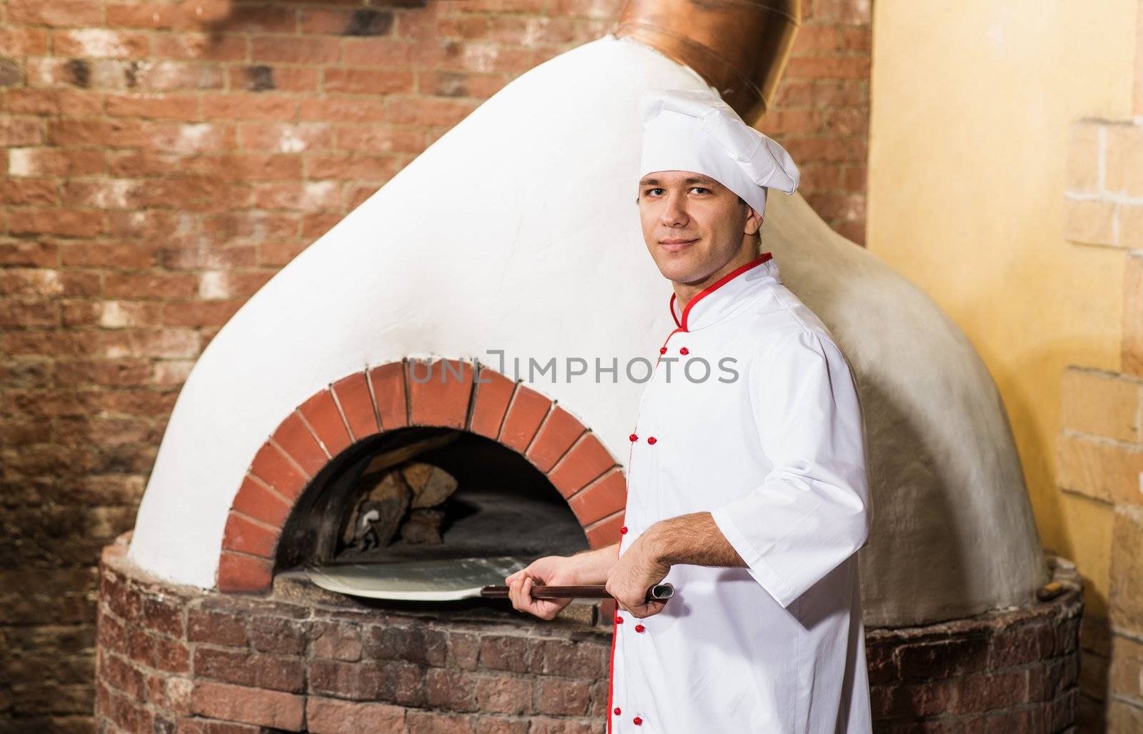 Chef puts dough in the oven for pizzas, traditional cooking