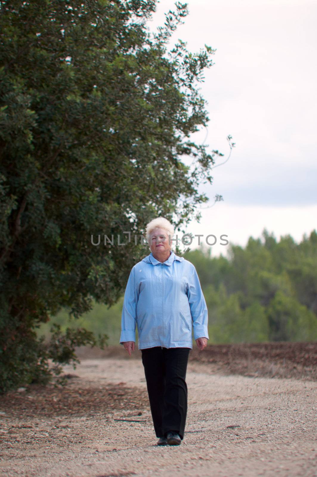 Senior women walking on a path .