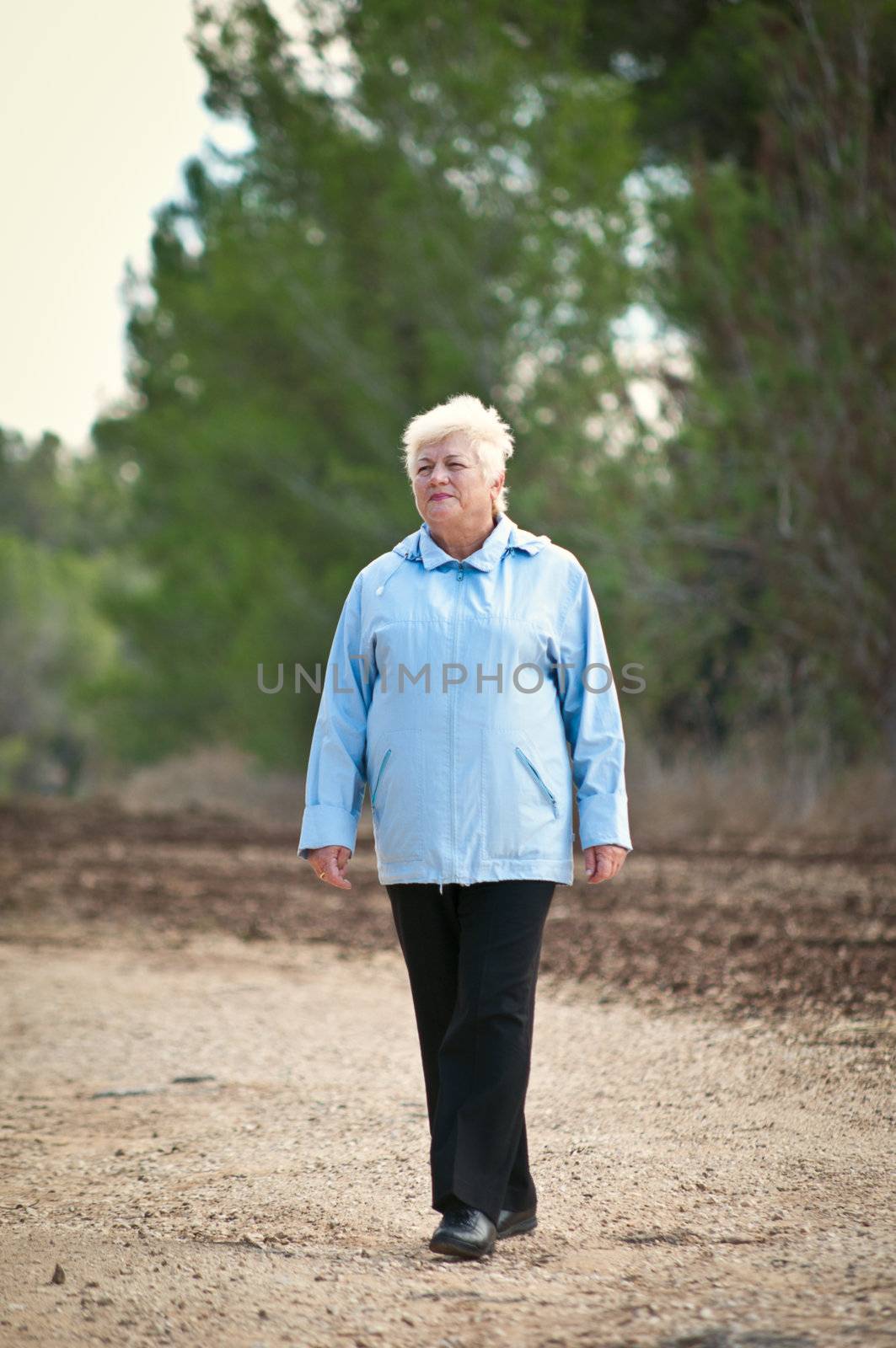 Senior women walking on a path .