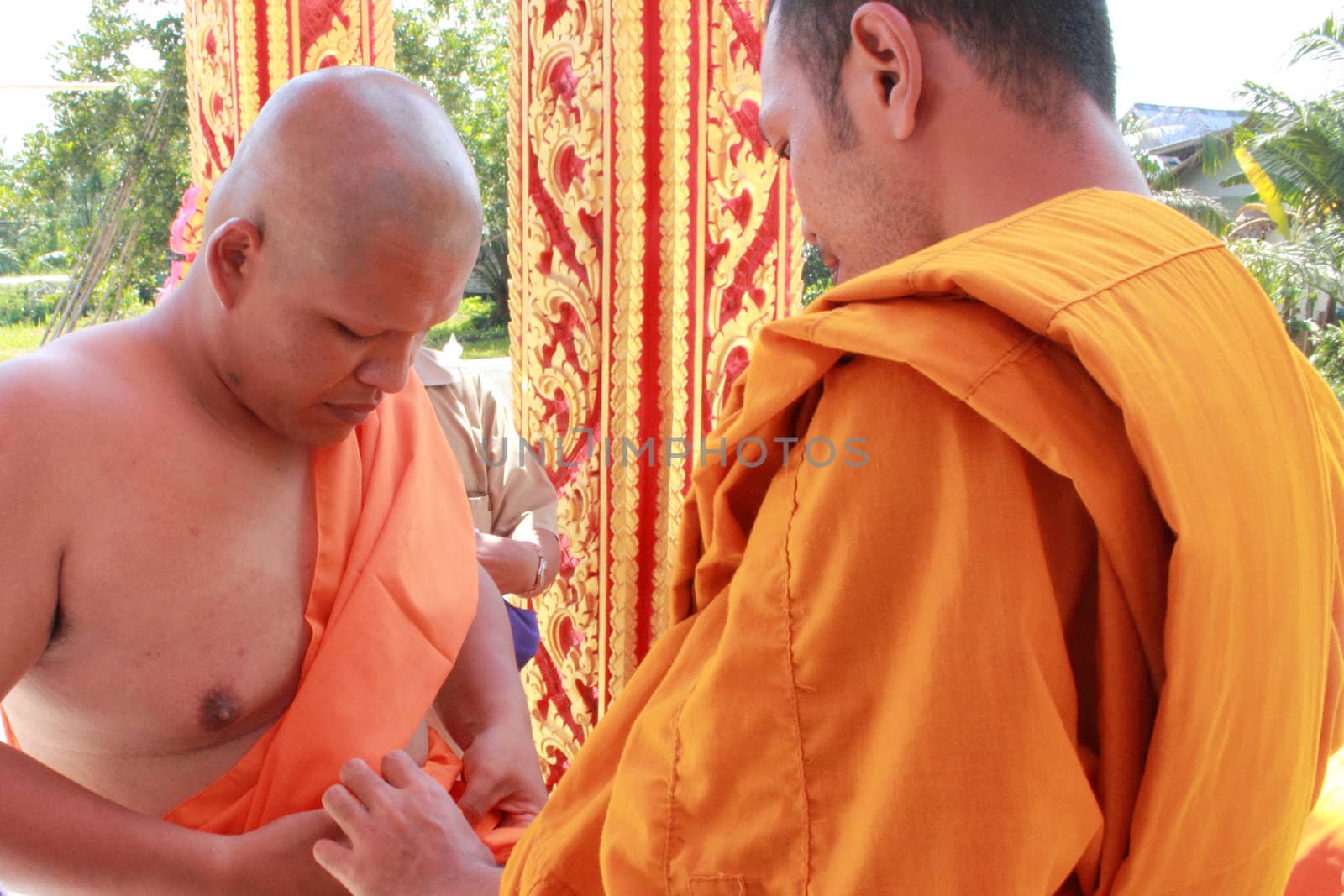 NAKON SI THAMMARAT, THAILAND - NOVEMBER 17 : The senior monk dress the new monk in the Newly Buddhist ordination ceremony on November 17, 2012 in Nakon Si Thammarat, Thailand.