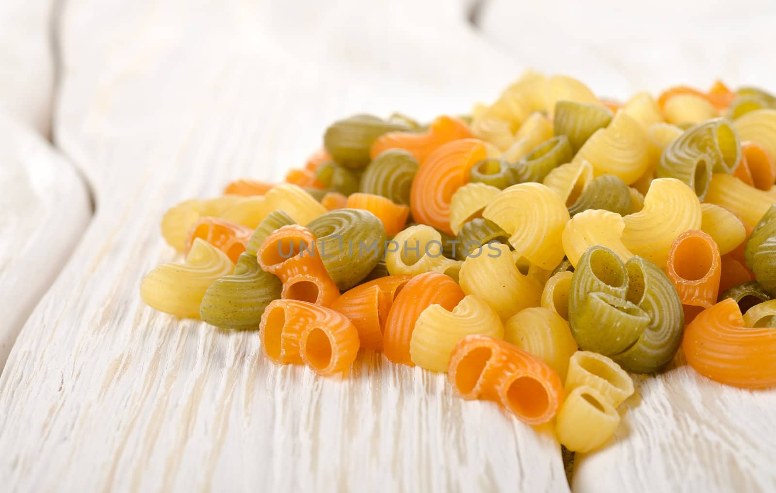 Colorful pasta on a white wooden table