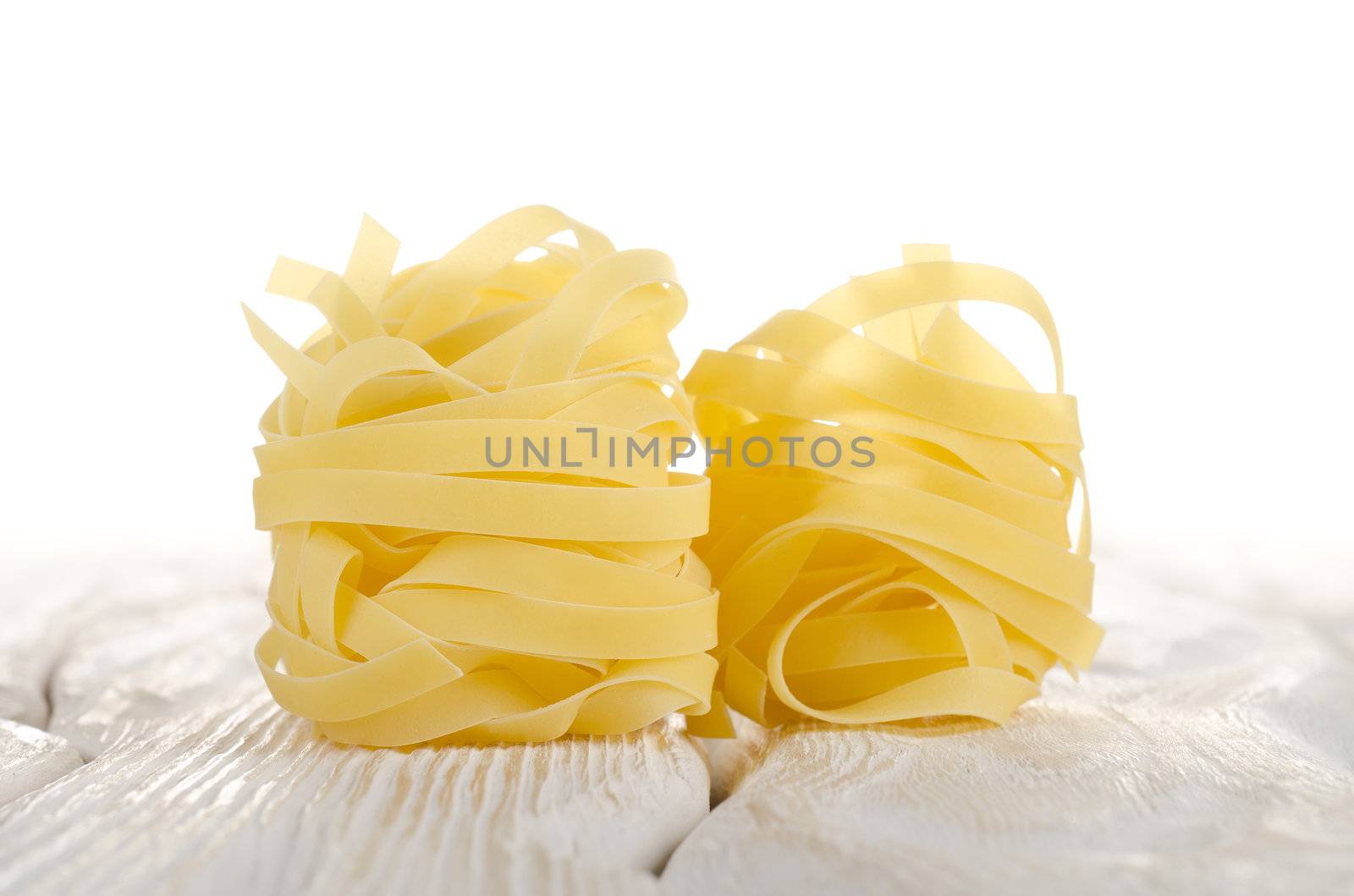 Pasta tagliatelle on a white wooden table