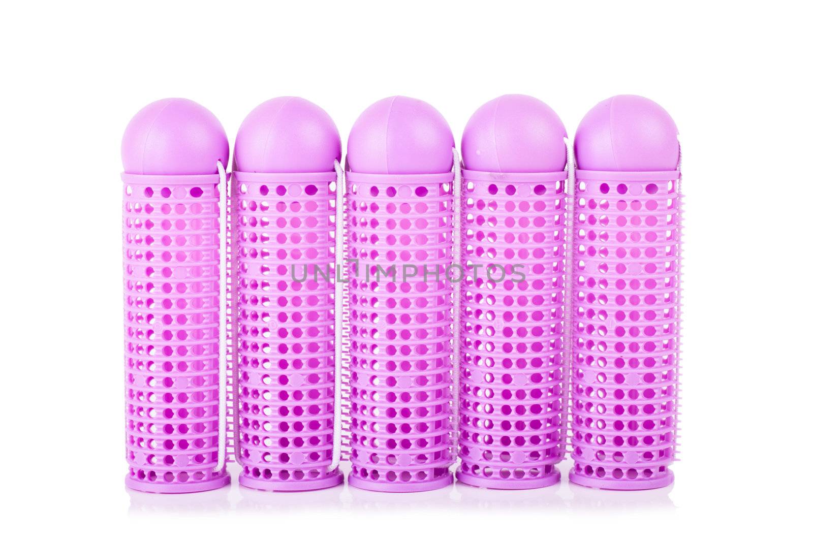 Closeup view of pink hair curlers over white background
