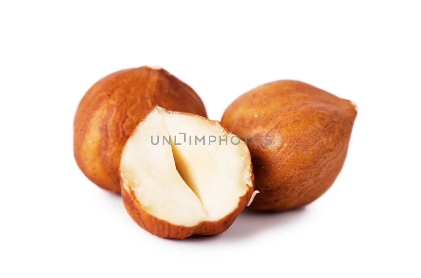 Closeup view of hazelnuts over white background