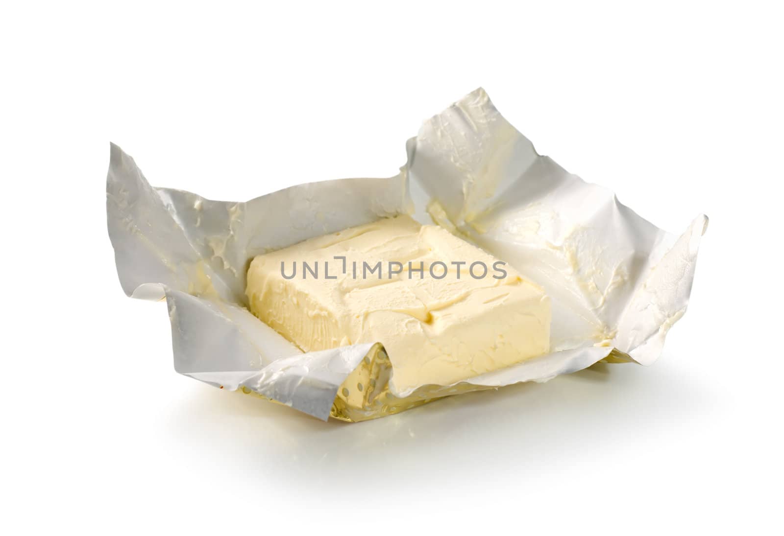 Creamy butter in its unwrapped foil paper. Isolated on white (Path)