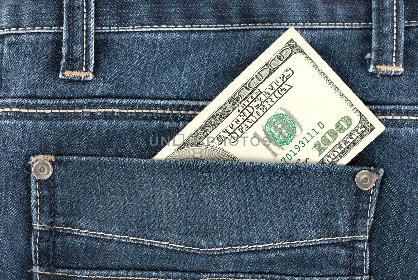 A one hundred dollar note in the back pocket of denim trousers