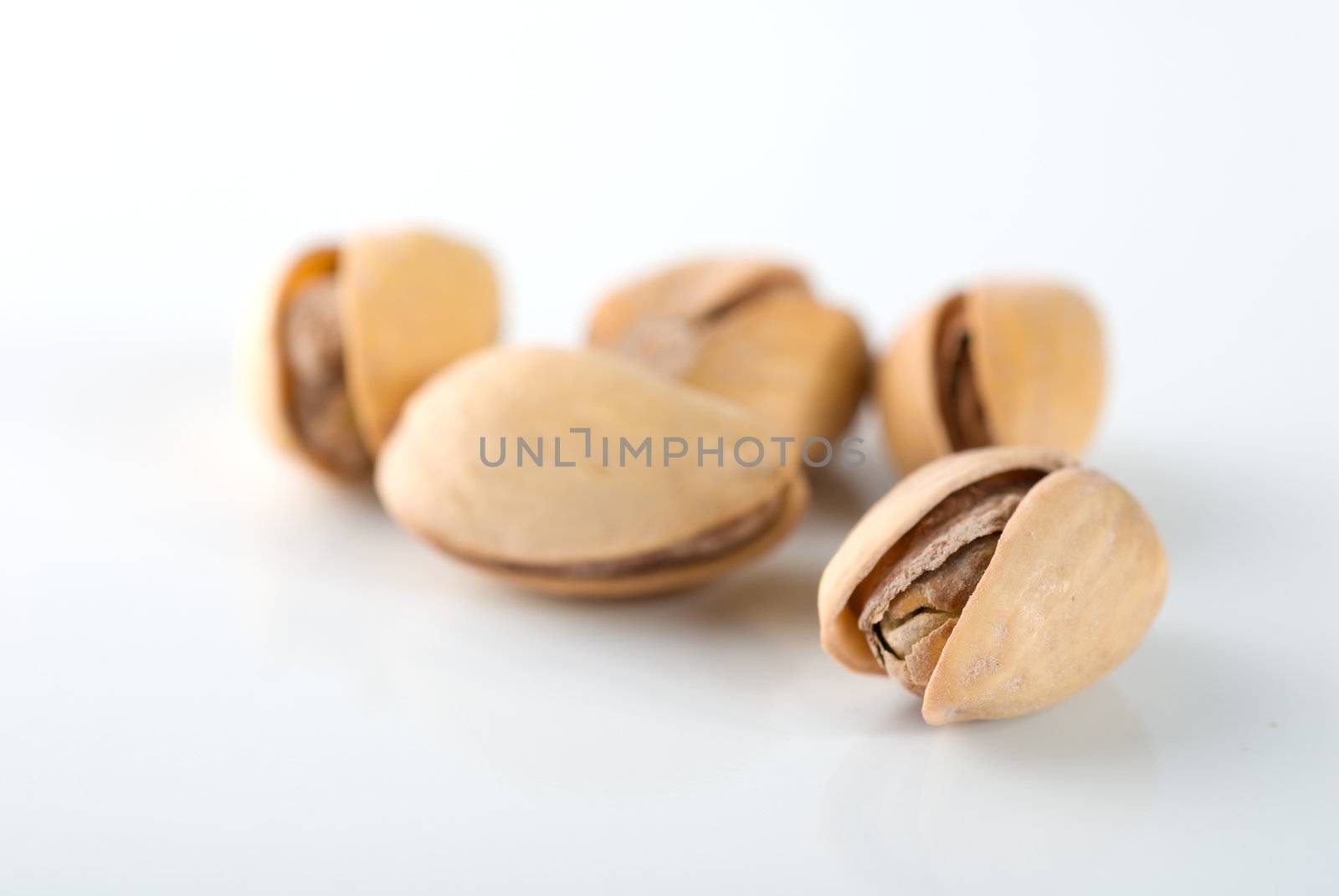 Handful of ripe pistachios on a white background