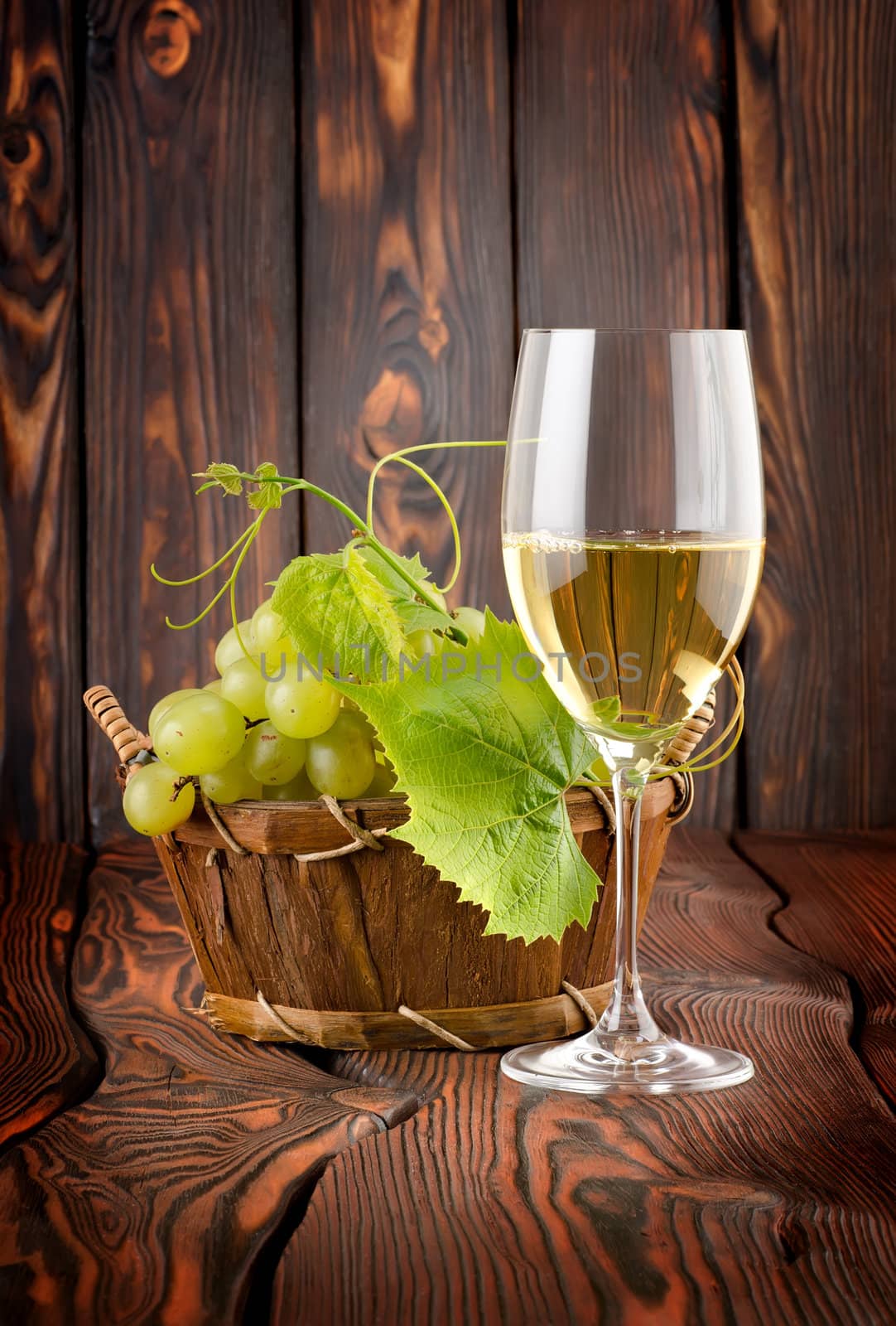 White wine with grapes on wooden background