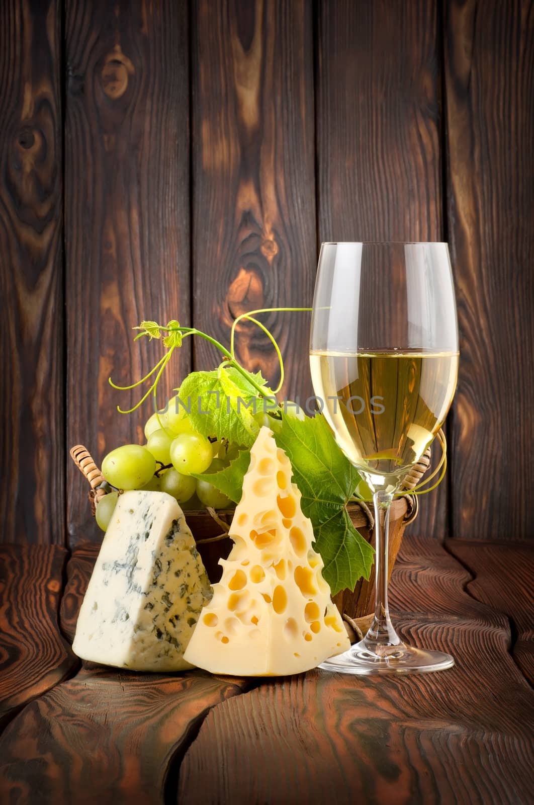 White wine with grapes on wooden background