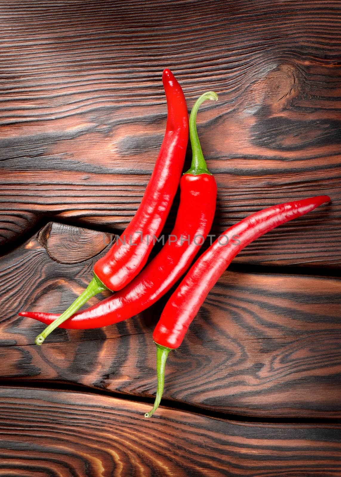 Chili on a wooden background by Givaga