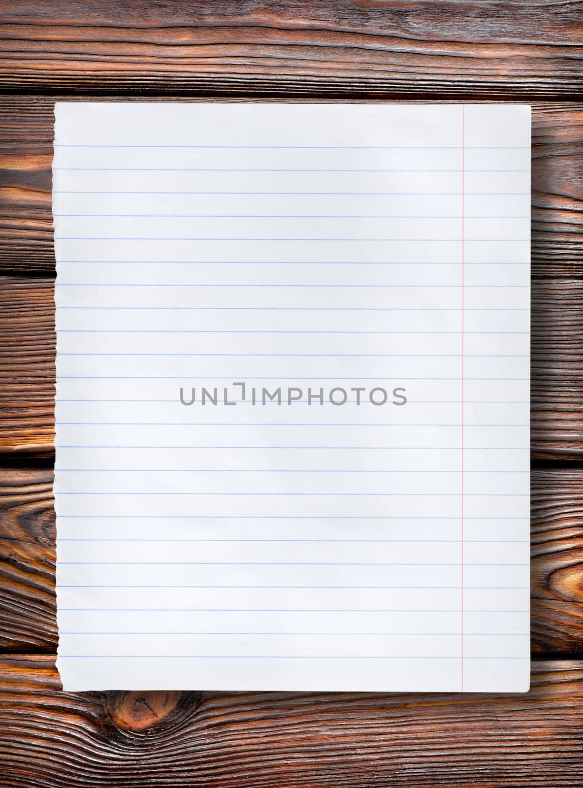 Lined paper on a dark wooden table