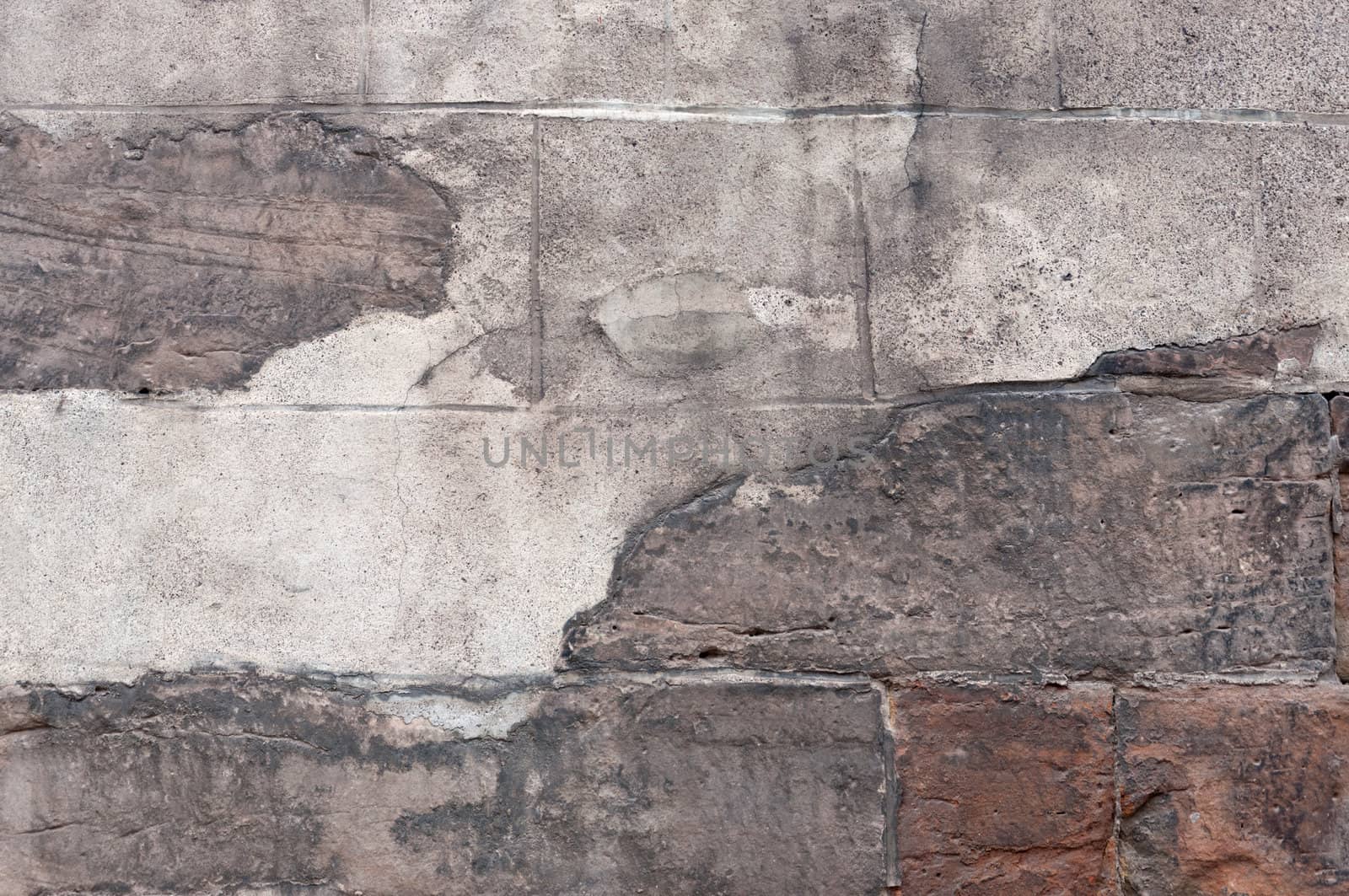 Old stone wall with peeling plaster.