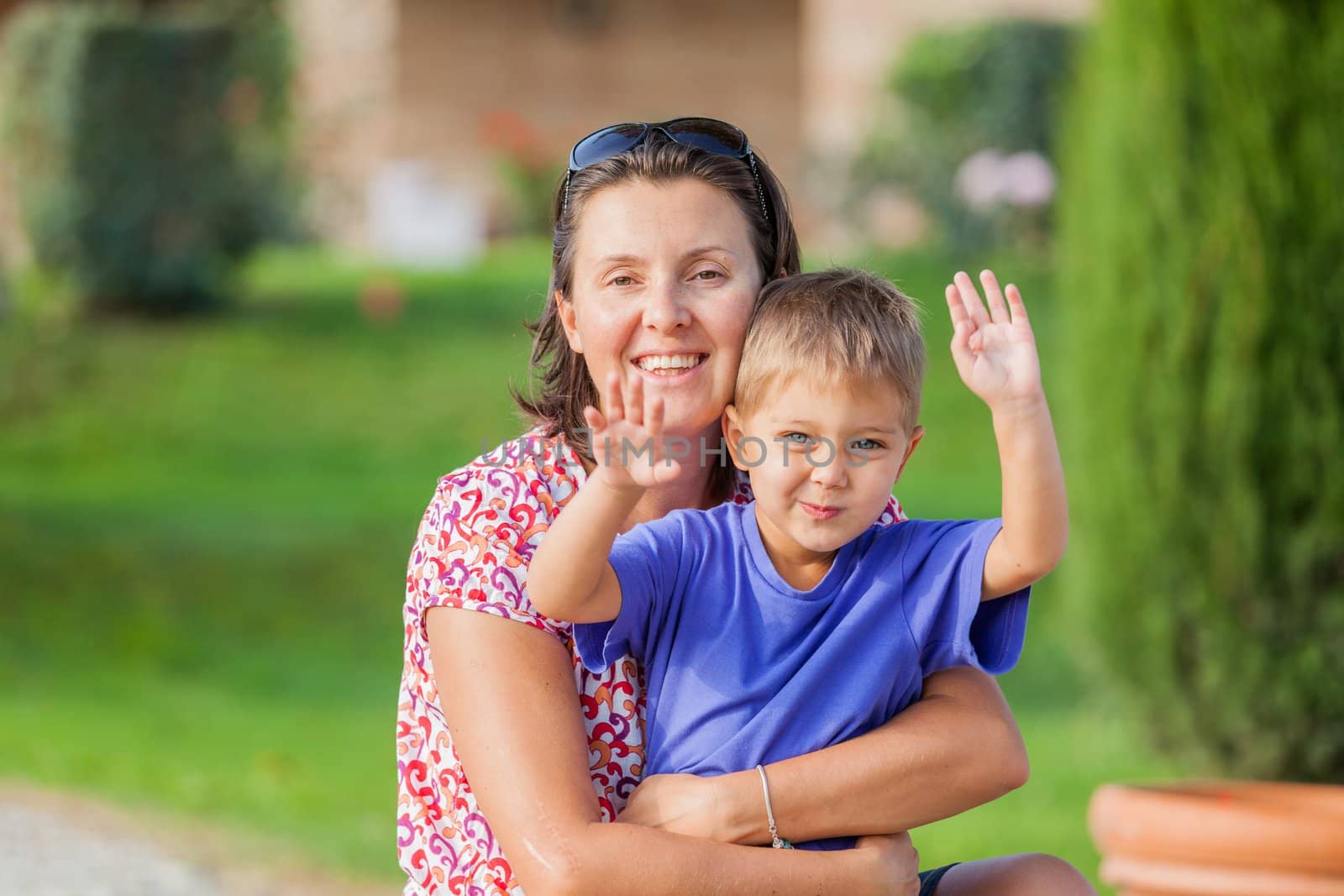 Portrait of a happy little boy with his mother in the garden