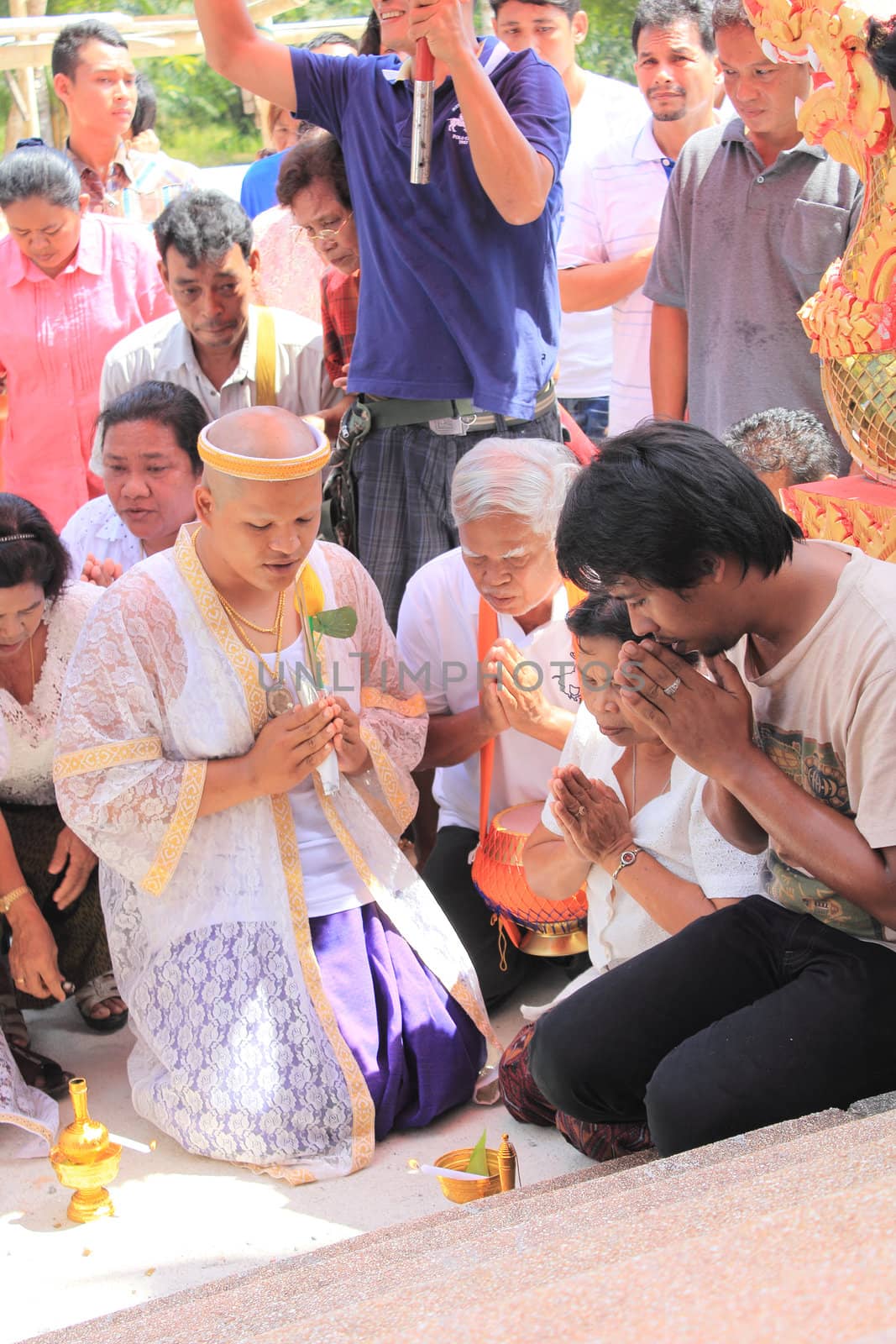 NAKON SI THAMMARAT, THAILAND - NOVEMBER 17 : Unidentified Thai people pour water after circle temple with offering Buddhist ordination ceremony on November 17, 2012 in Nakon Si Thammarat, Thailand.