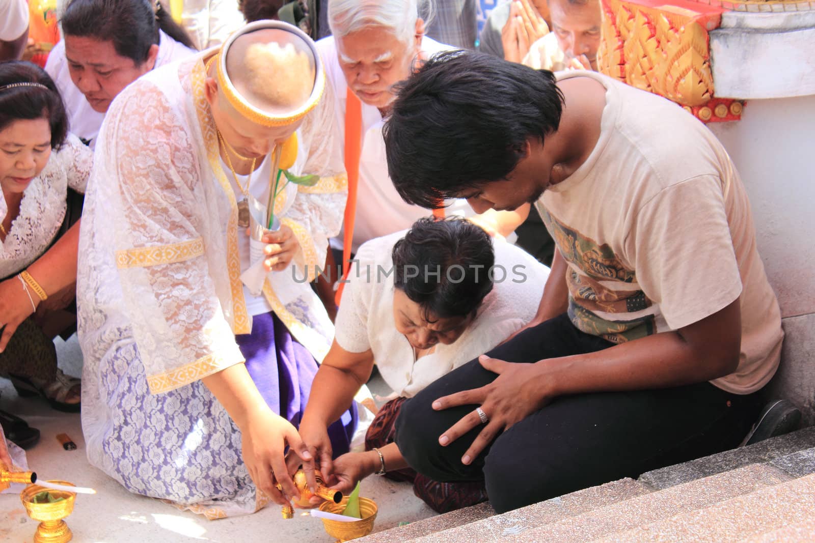 NAKON SI THAMMARAT, THAILAND - NOVEMBER 17 : Unidentified Thai people pour water after circle temple with offering Buddhist ordination ceremony on November 17, 2012 in Nakon Si Thammarat, Thailand.