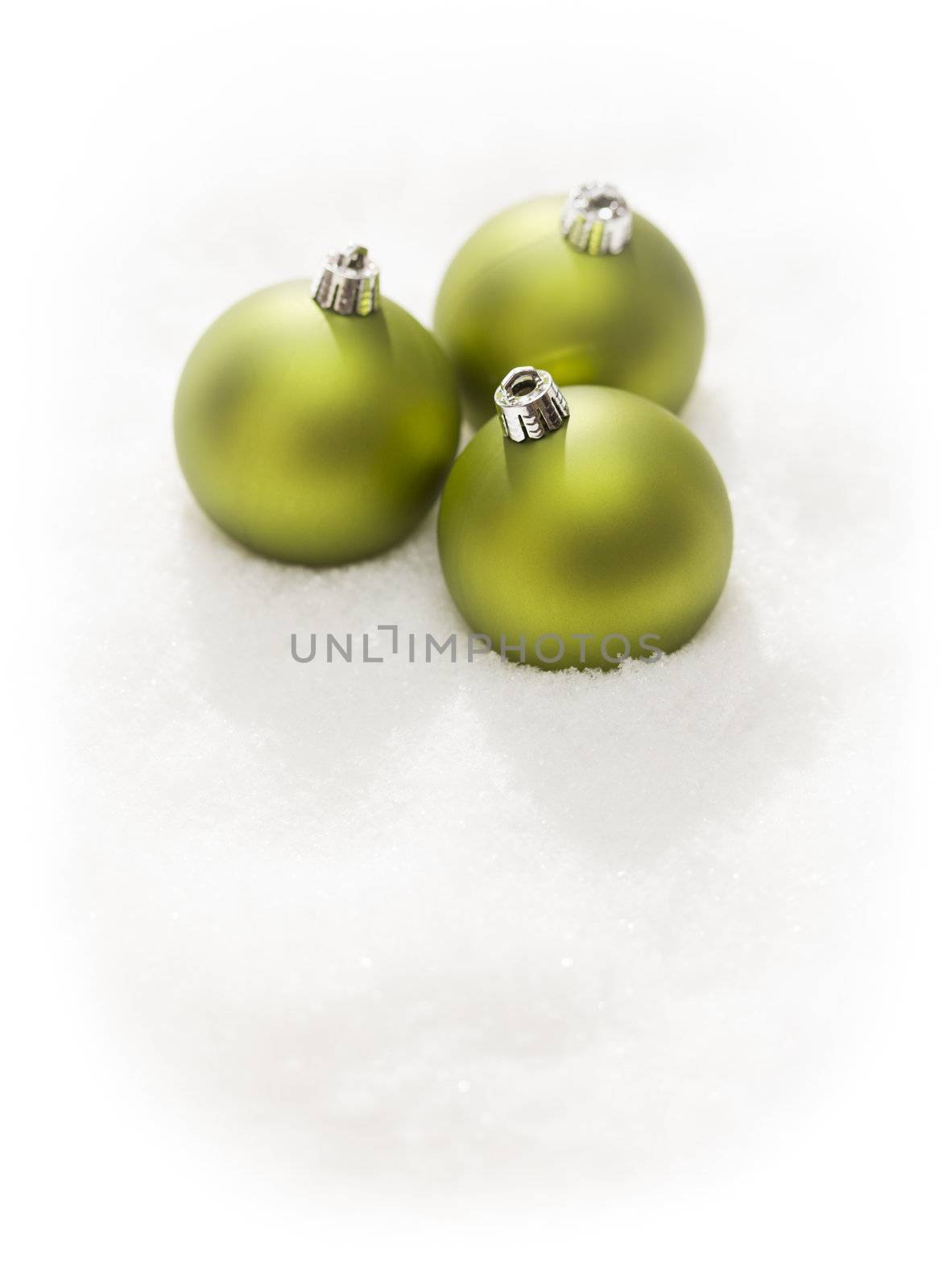 Three Green Christmas Ornaments on Snow Flakes Isolated on a White Background