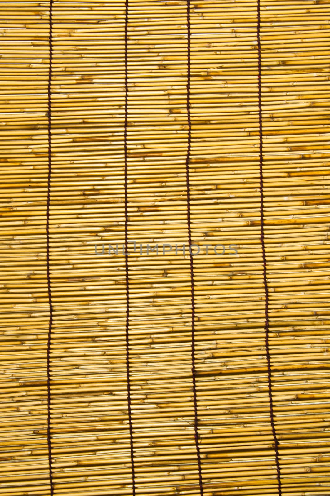 This is a wall of bamboo are woven together in a large sheet.