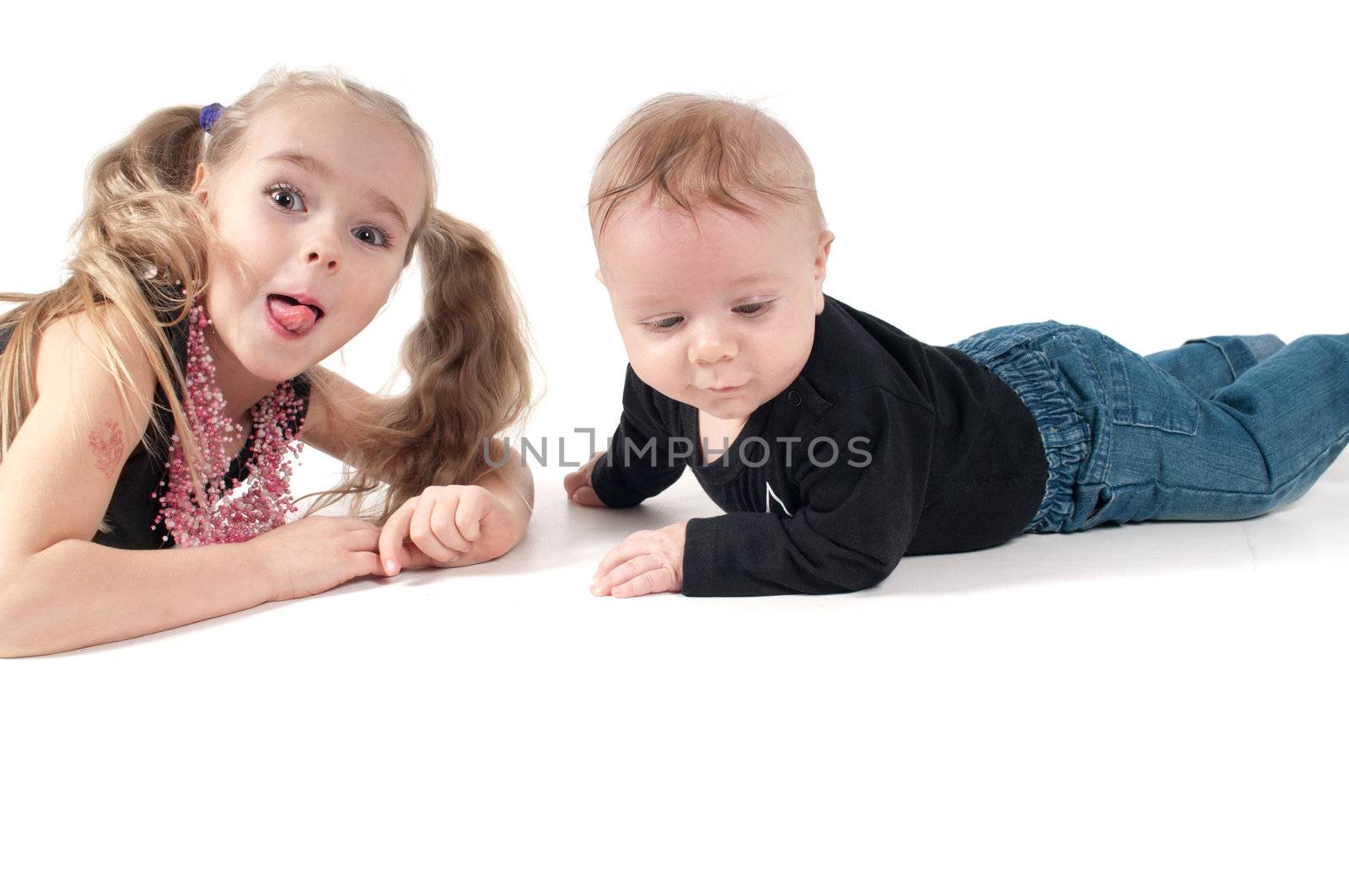 Newborn baby boy with sister showing tongue