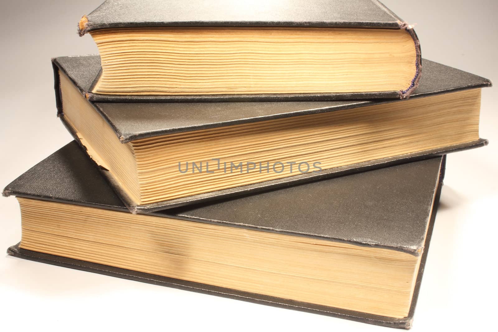 Three old books on white background
